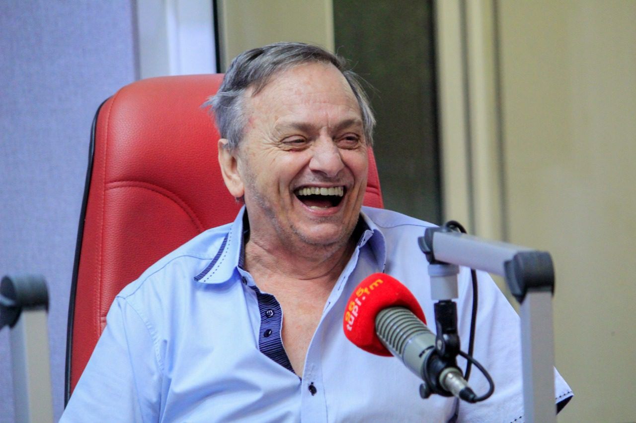 Profissional em estúdio de rádio ao microfone durante transmissão