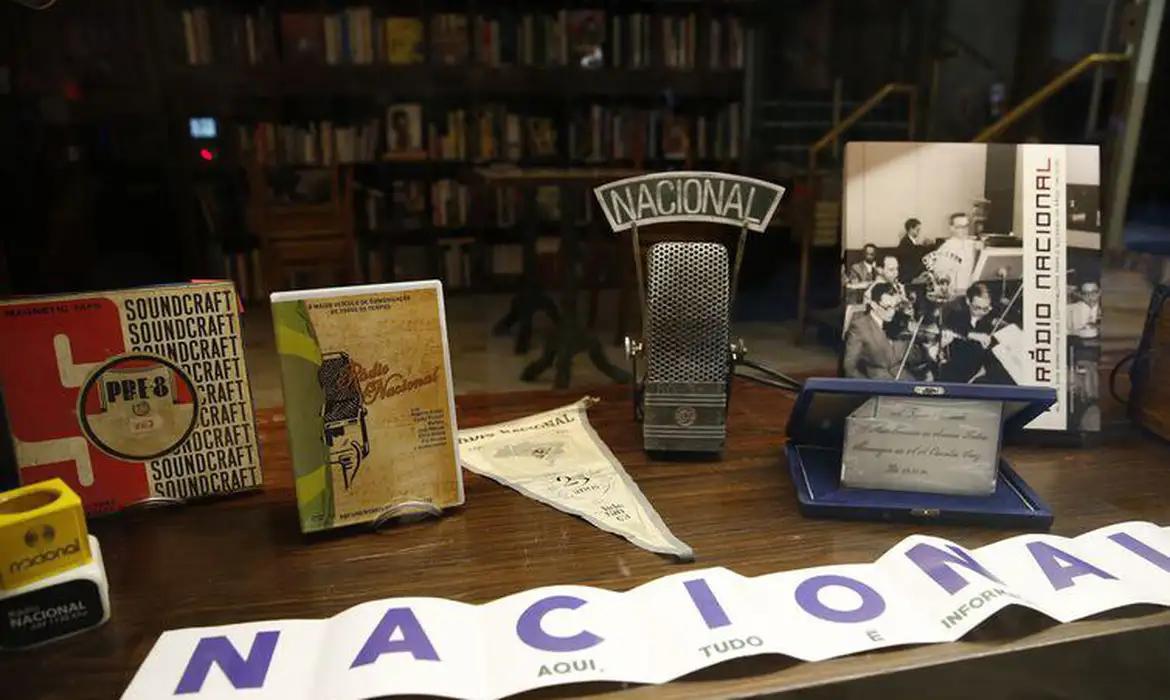 Acervo do Museu da Rádio Nacional com microfone vintage, fitas magnéticas, discos e fotografias históricas da emissora