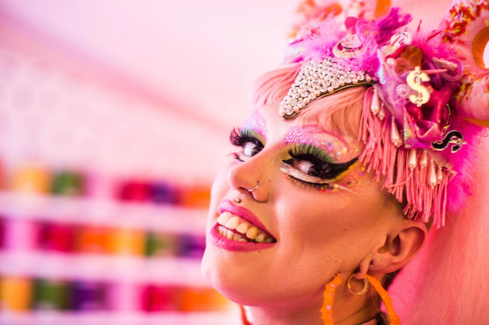 Drag queens dançando em batida de lip sync em palco iluminado