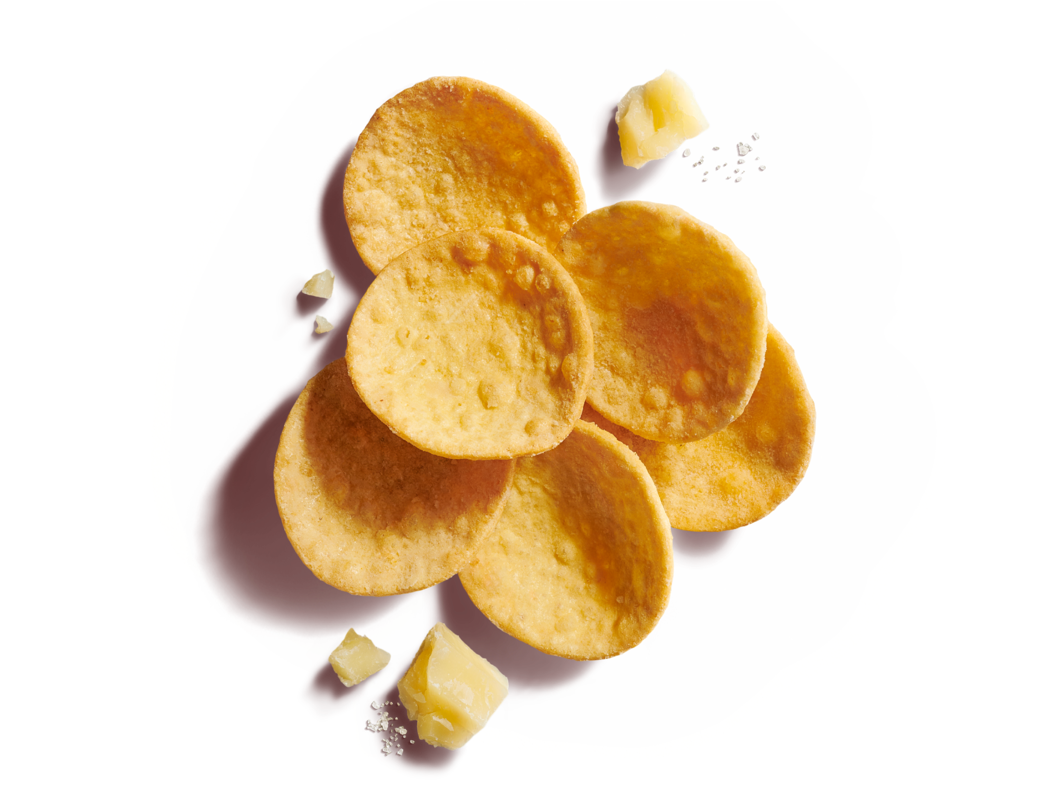 Close-up of six scattered round, curved scoop crackers on a dark yellow background with hard cheese and sea salt flakes.
