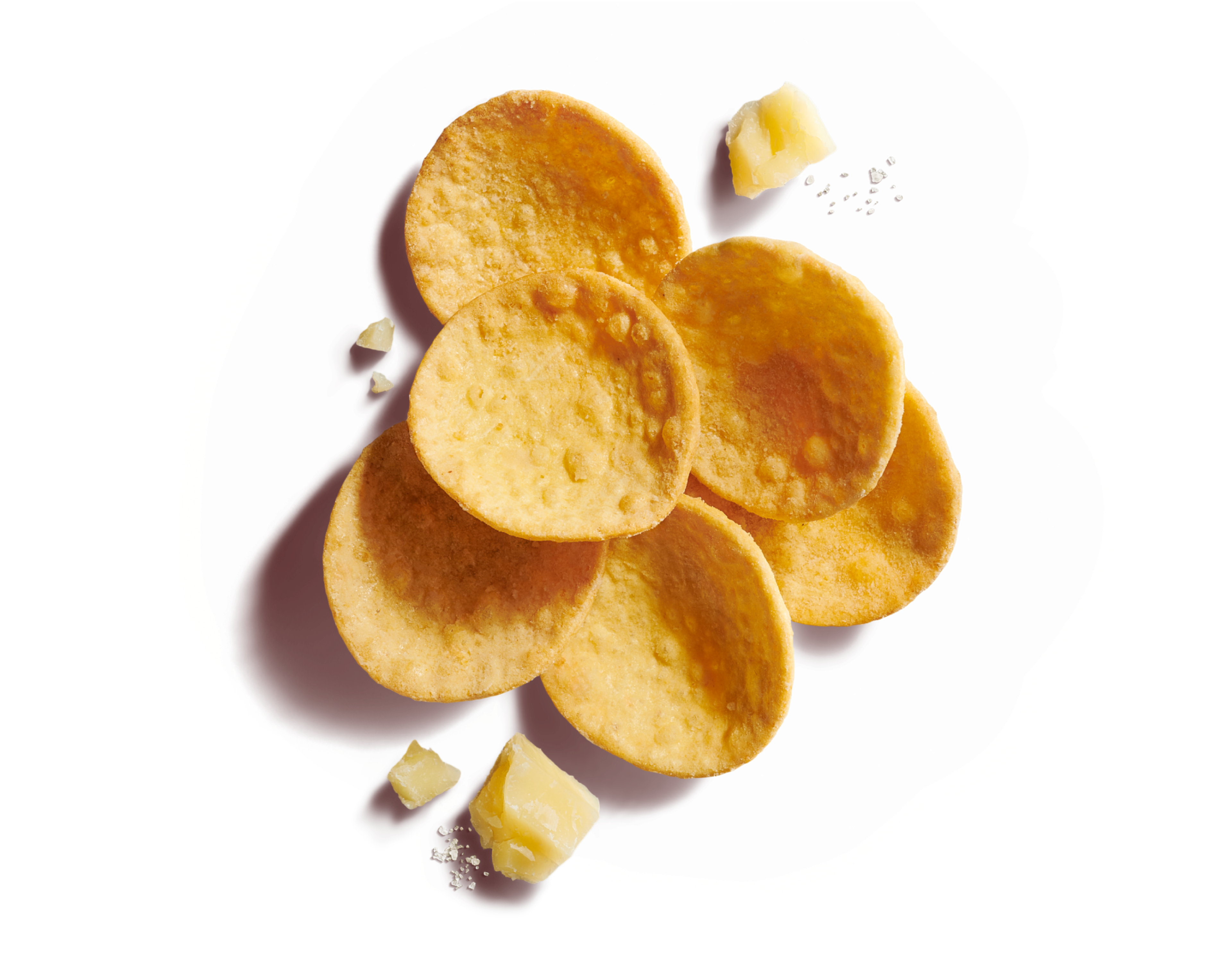 Close-up of six scattered round, curved scoop crackers on a dark yellow background with hard cheese and sea salt flakes.