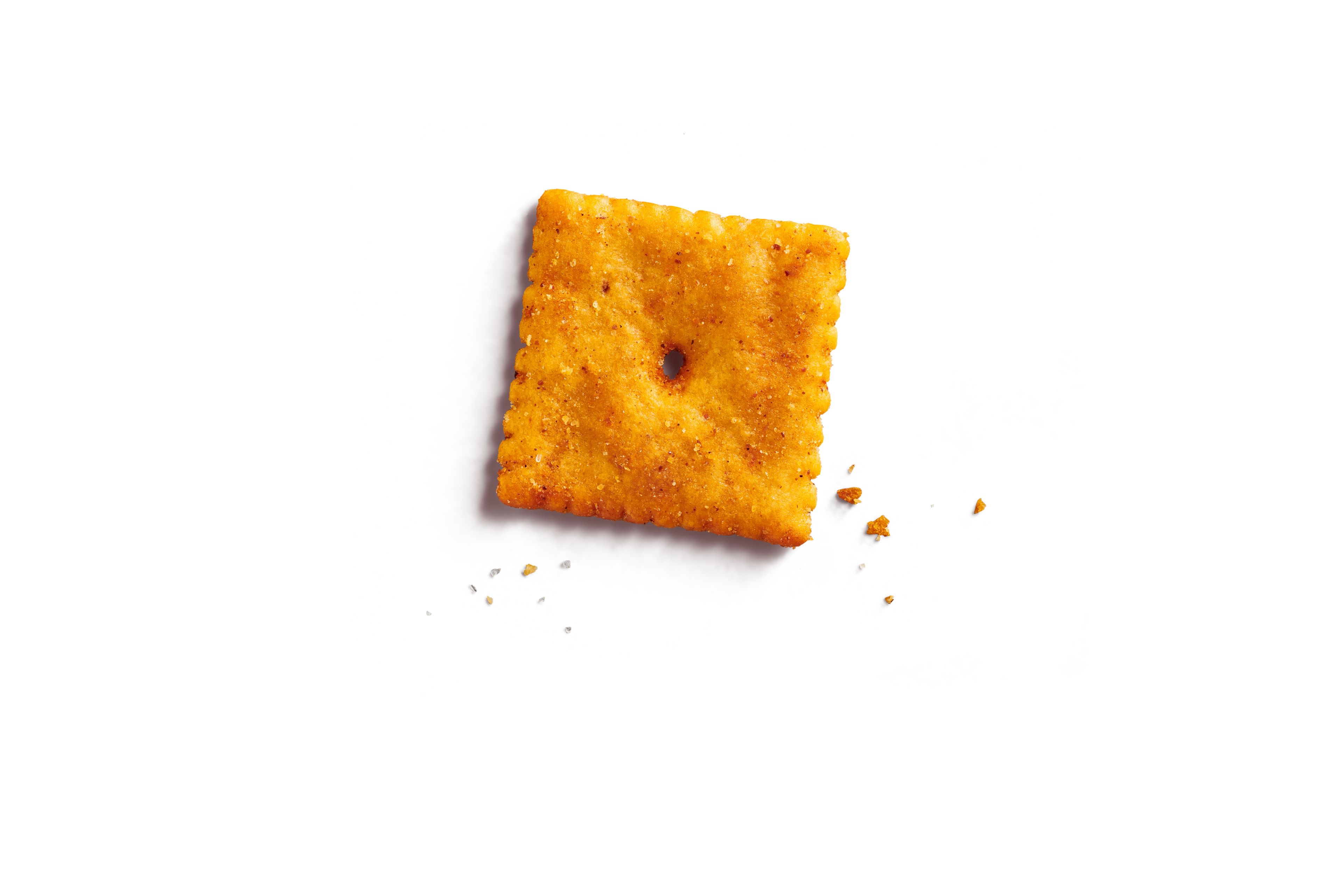 Close up of a hot & spicy cheezy cracker. The reddish seasoning is visible.