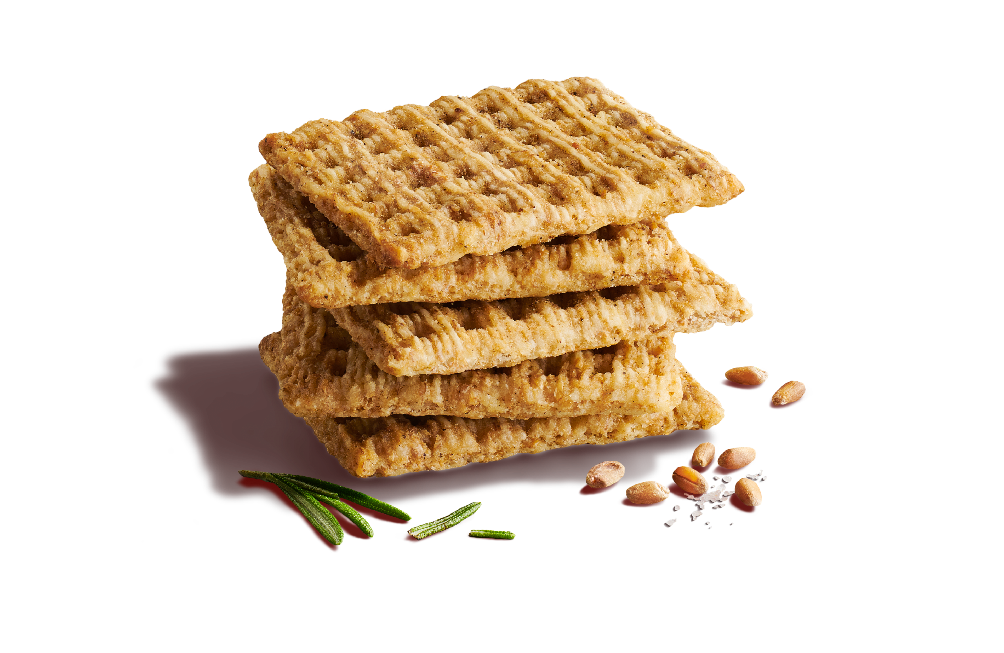 Close-up of two whole-grain woven wheat crackers on a light red background with slices of cheese topped with a few chopped tomatoes, onions, and rosemary.