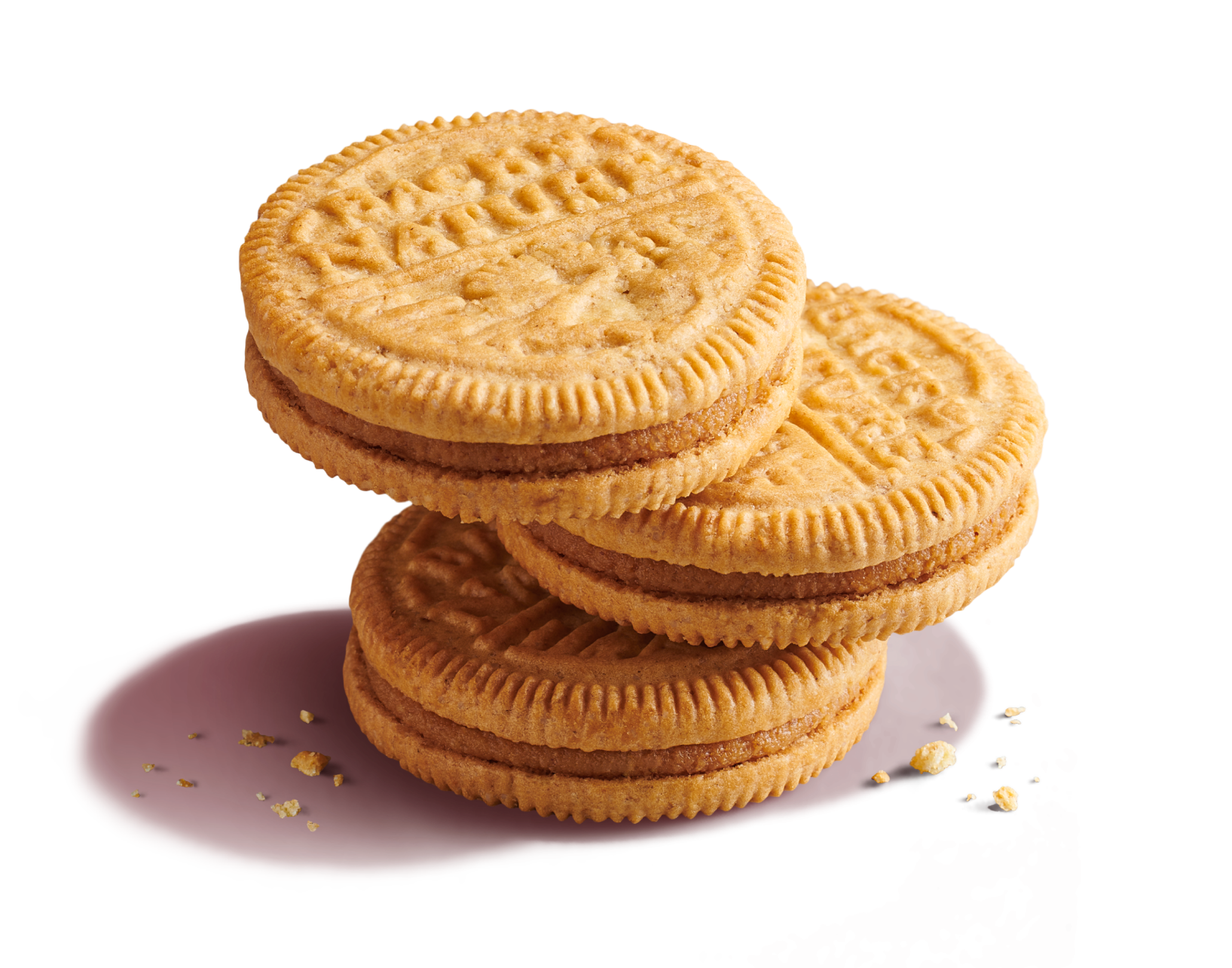 Three stacked Peanut Butter Creme Sandwich Cookies with peanut butter cookie crumbs, one cookie is bitten