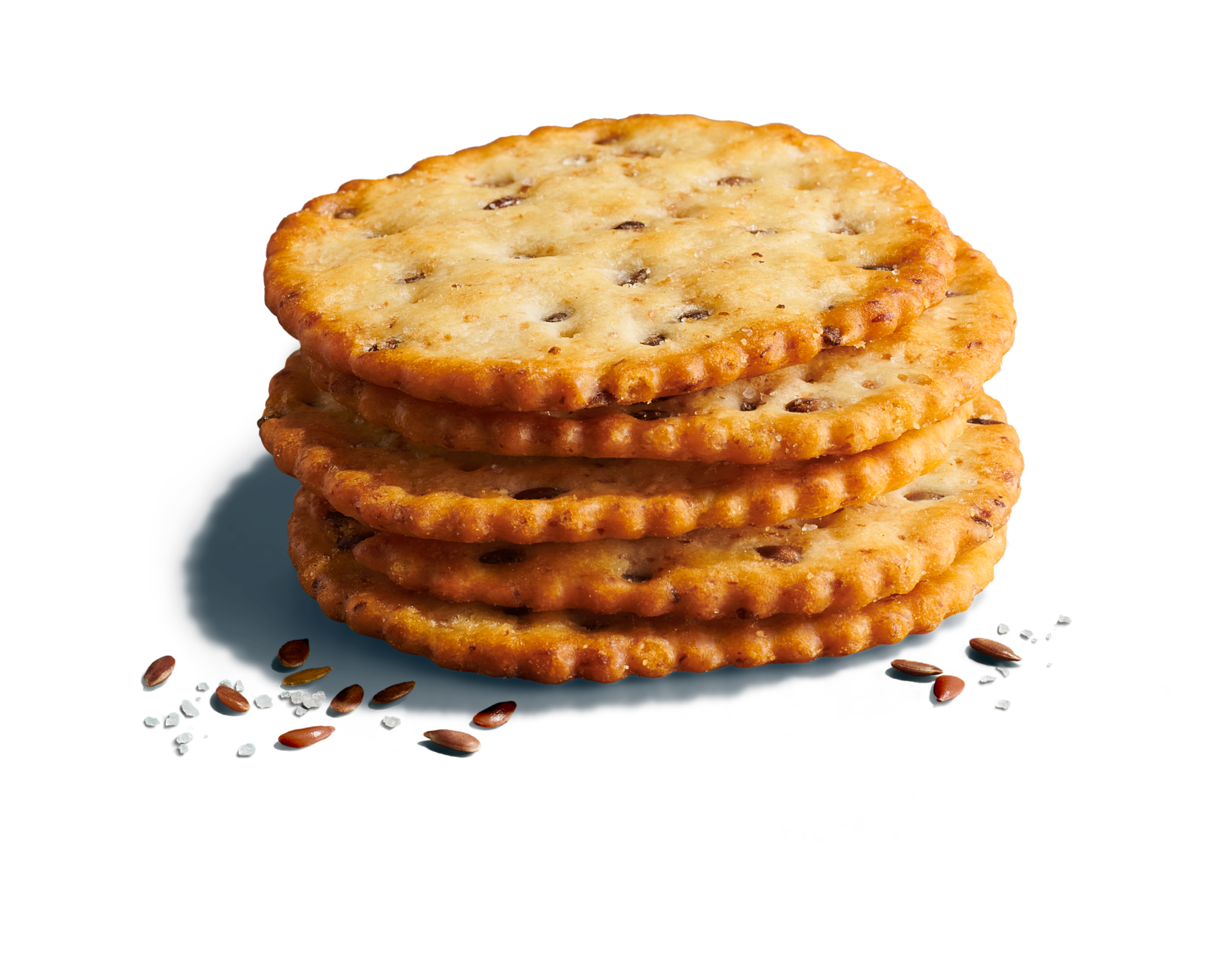 Close-up of five stacked round, seed crackers on a bright blue background with seeds and sea salt flakes.