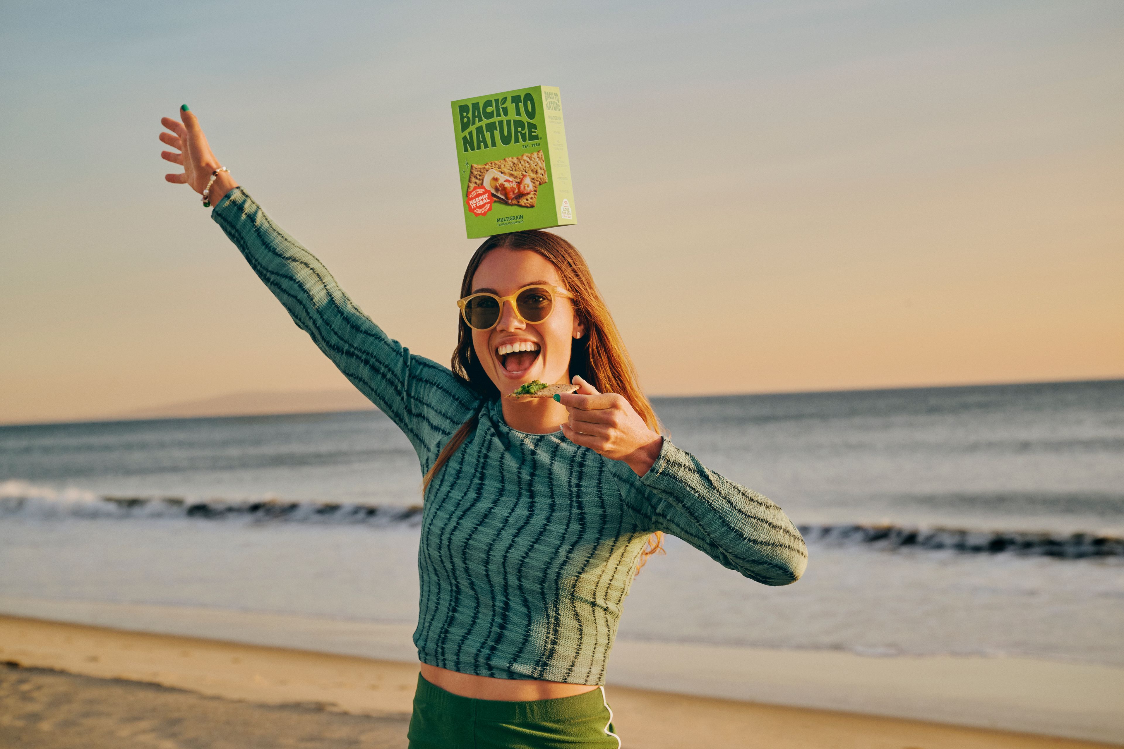 A woman eating crackers on the beach