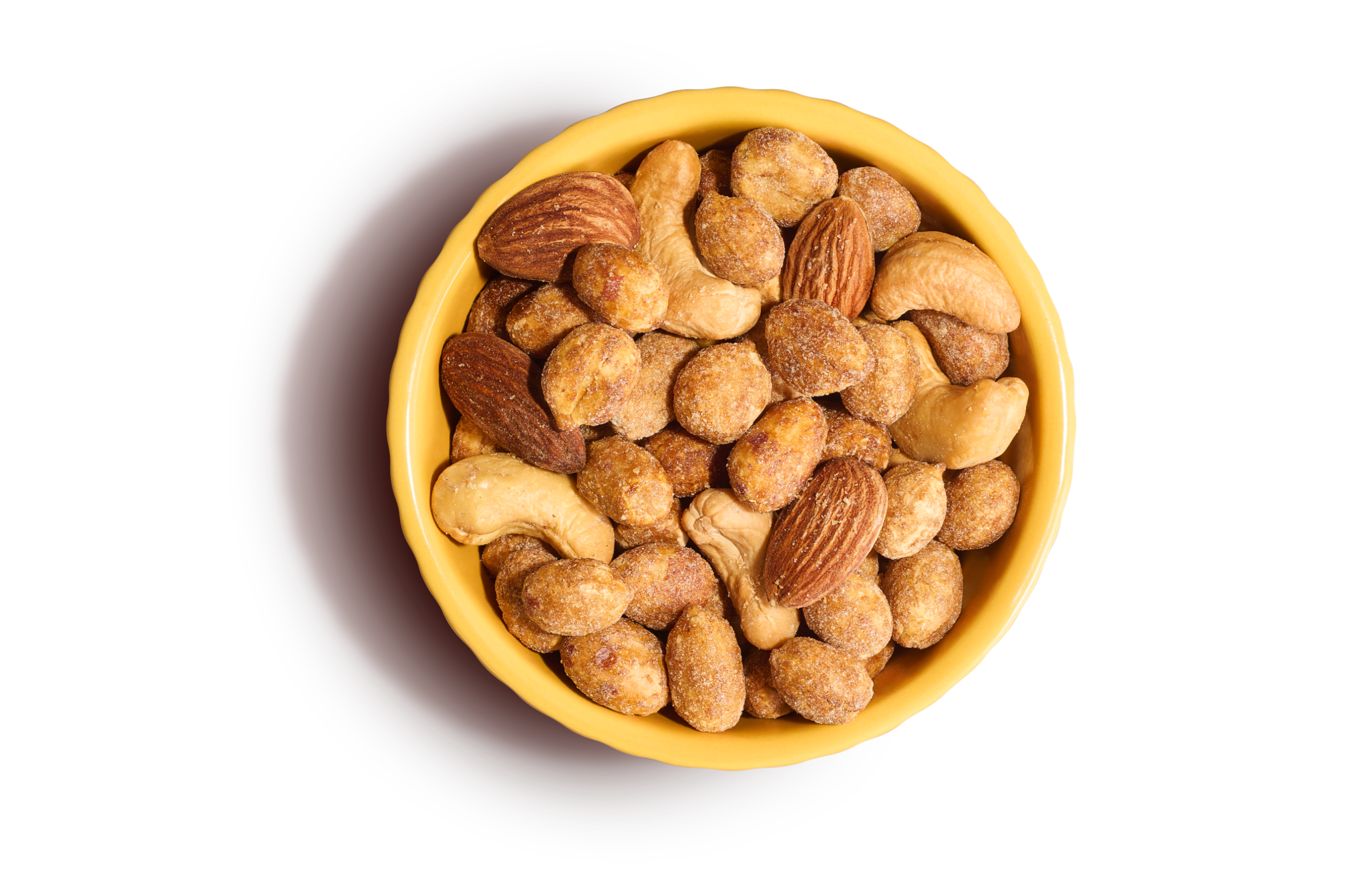 Light yellow bowl of honey roasted peanuts, salted cashews, and almonds on an yellow background.