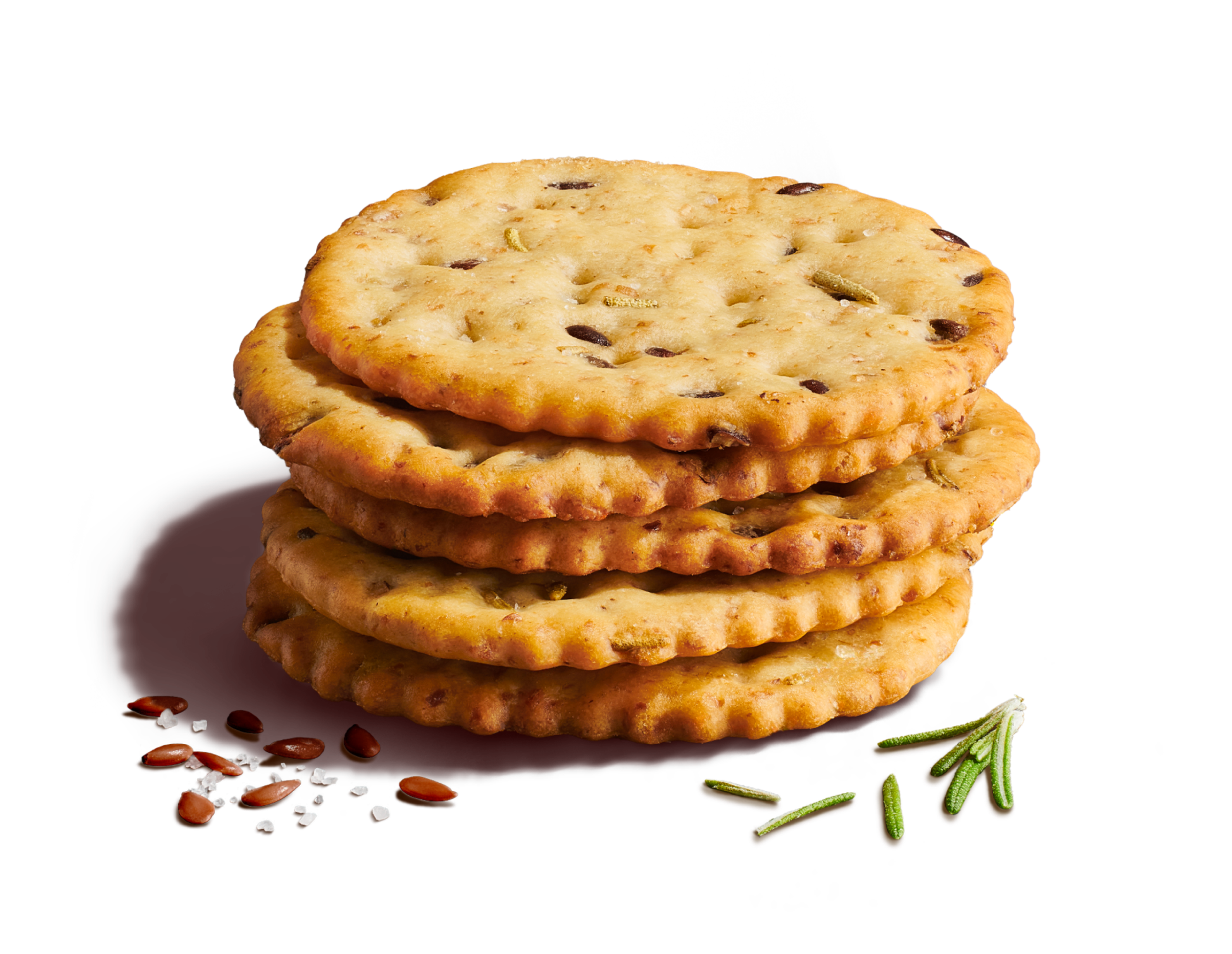 Close-up of five stacked crackers on a light yellow background with seeds, rosemary, and sea salt flakes.