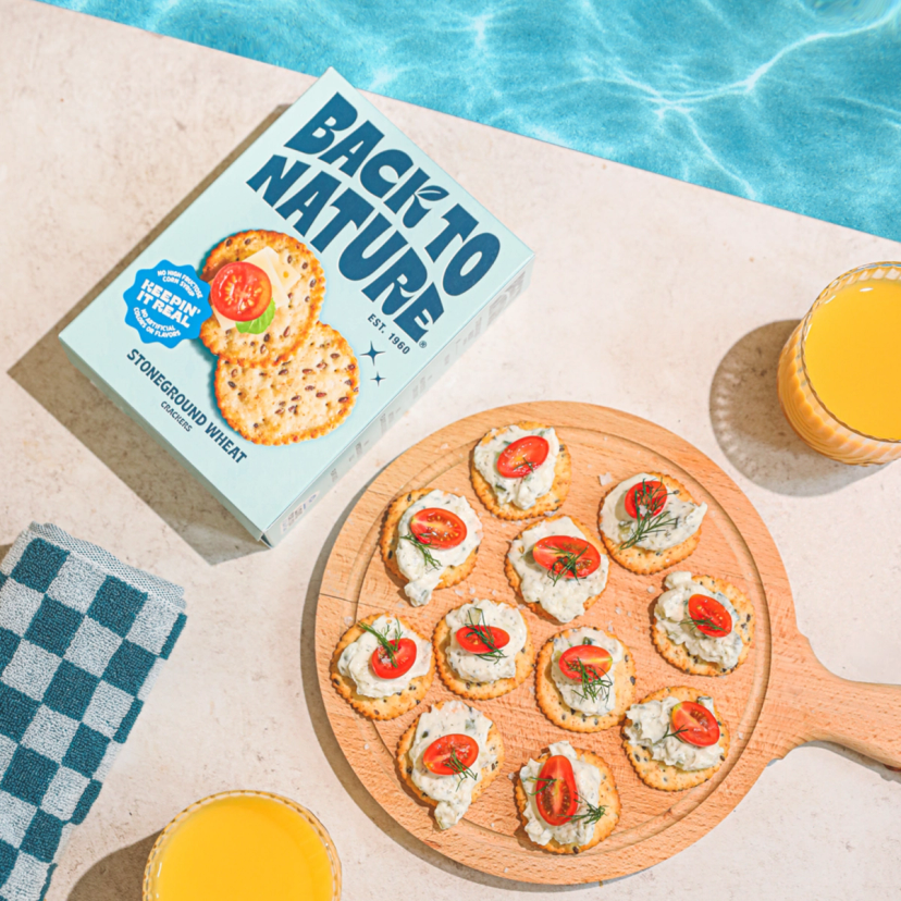 Back to Nature Stoneground Wheat crackers being served poolside, topped with hummus and tomato
