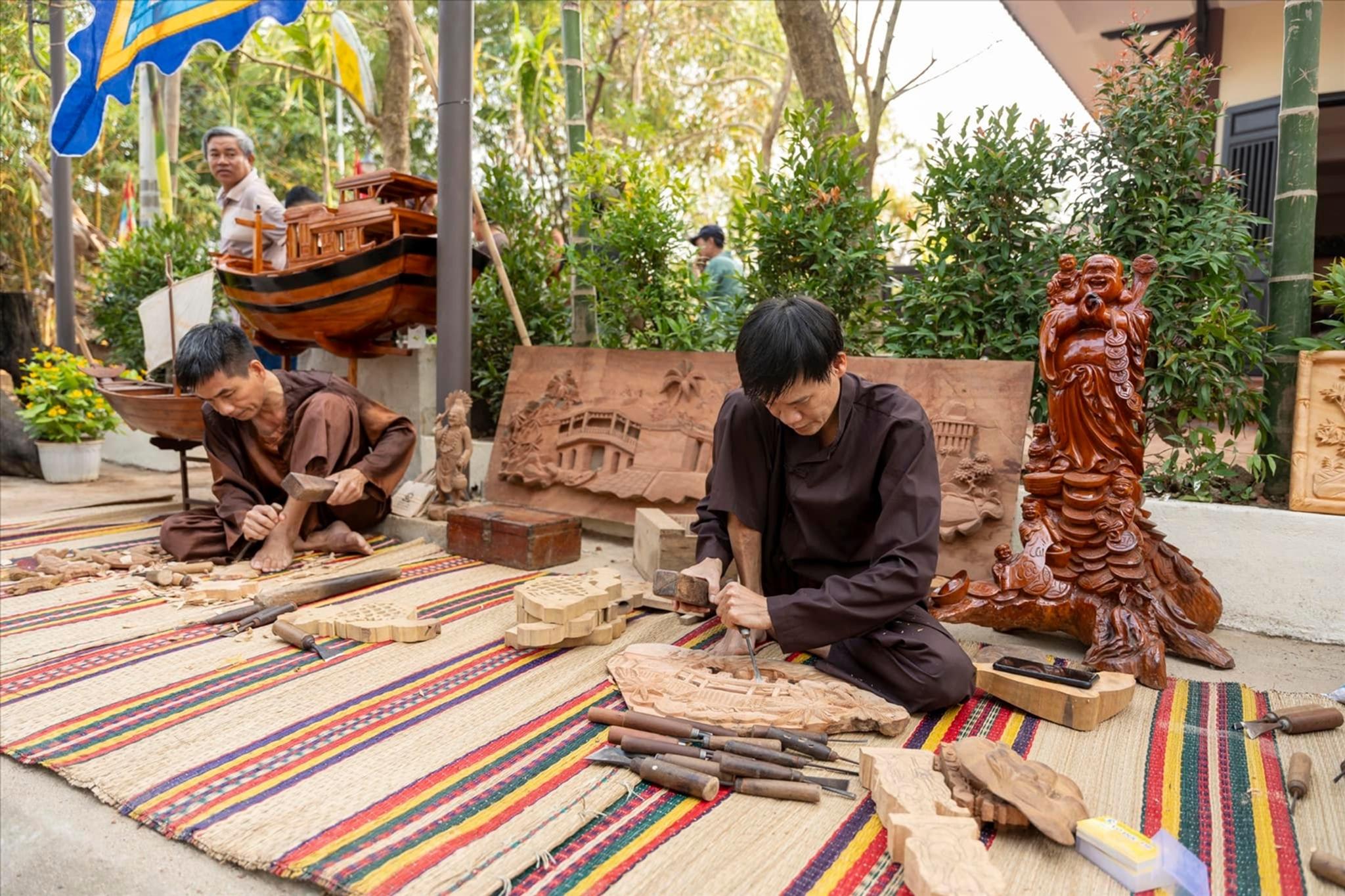 Guest trying wood carving with a master carpenter at Kim Bong village, Hoi An.
