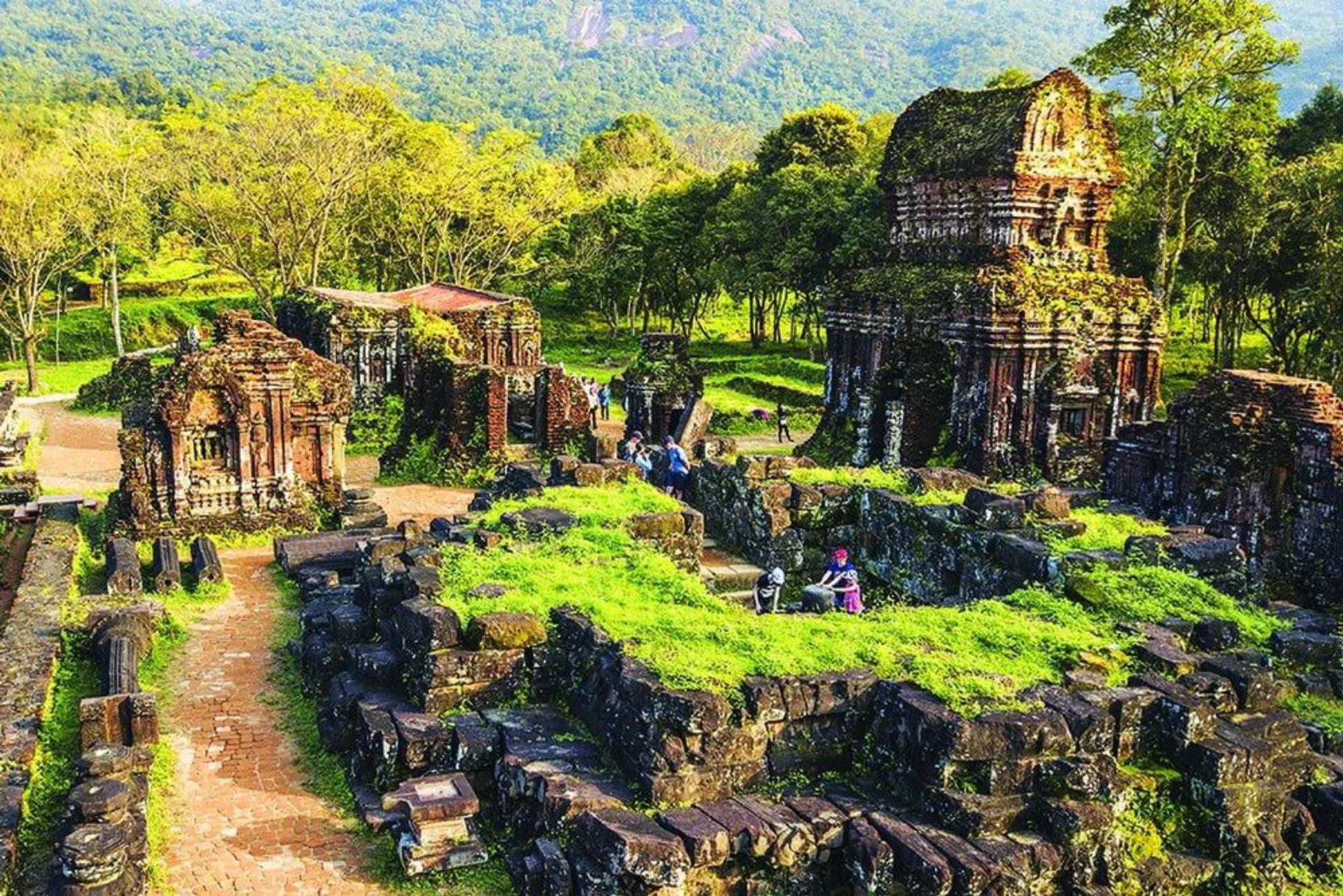 View over the moss-covered Cham temple complexes scattered through the My Son Sanctuary valley.