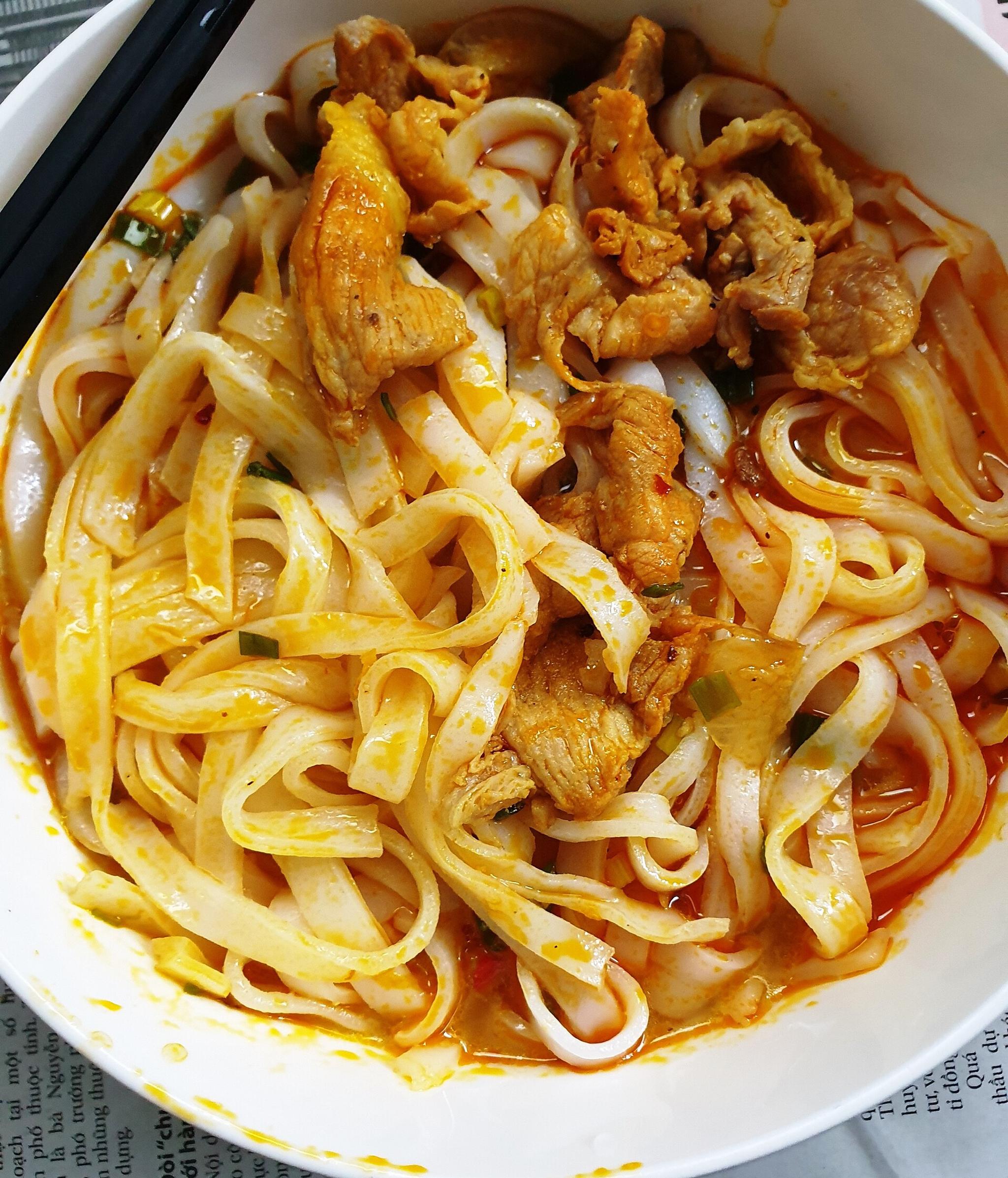 A bowl of mi Quang, the turmeric rice noodles of central Vietnam, with chicken.
