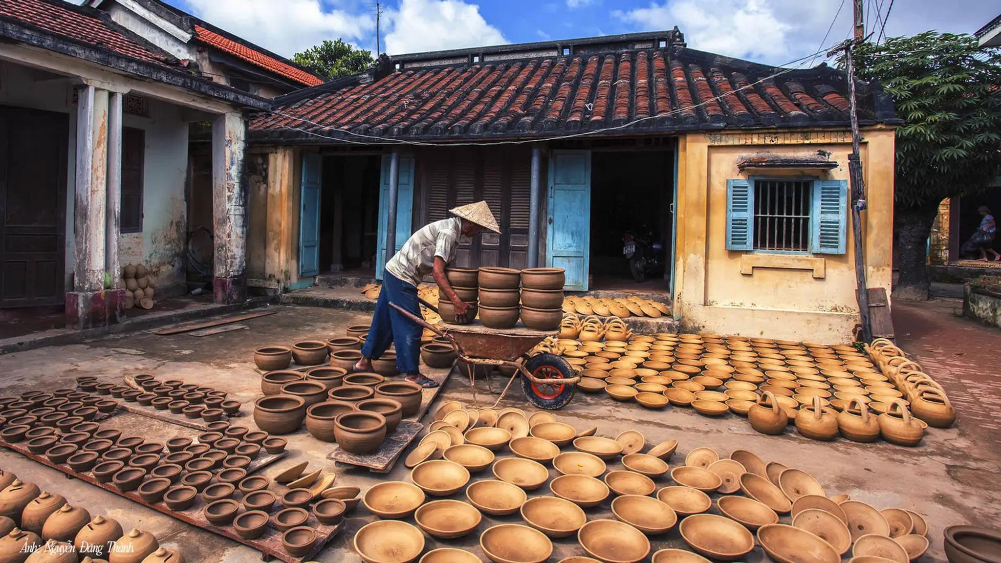 Hands forming clay at a Thanh Ha family workshop on the Thu Bon river.