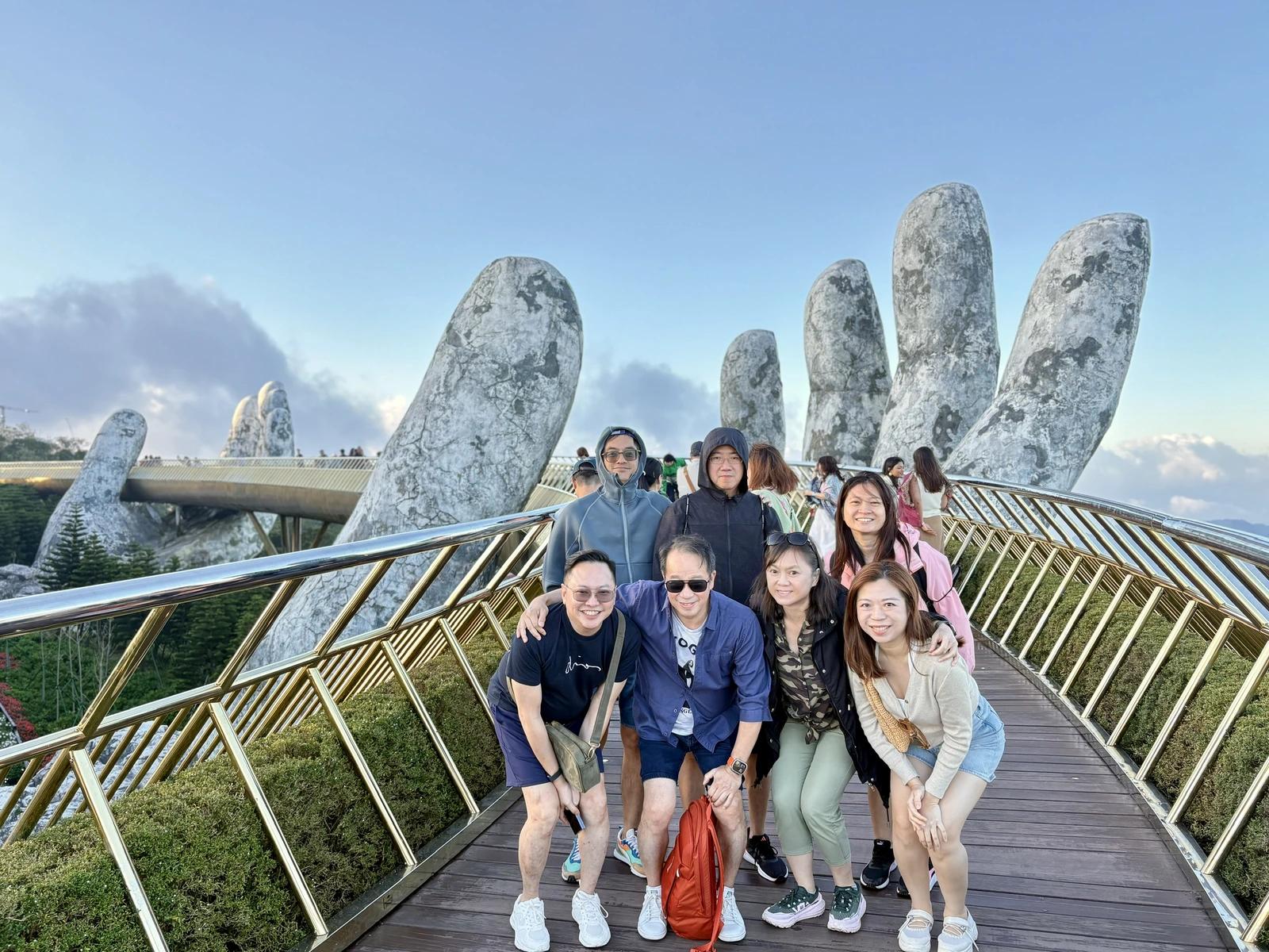 A Fingo group on the Golden Bridge at Ba Na Hills, held up by two giant stone hands.