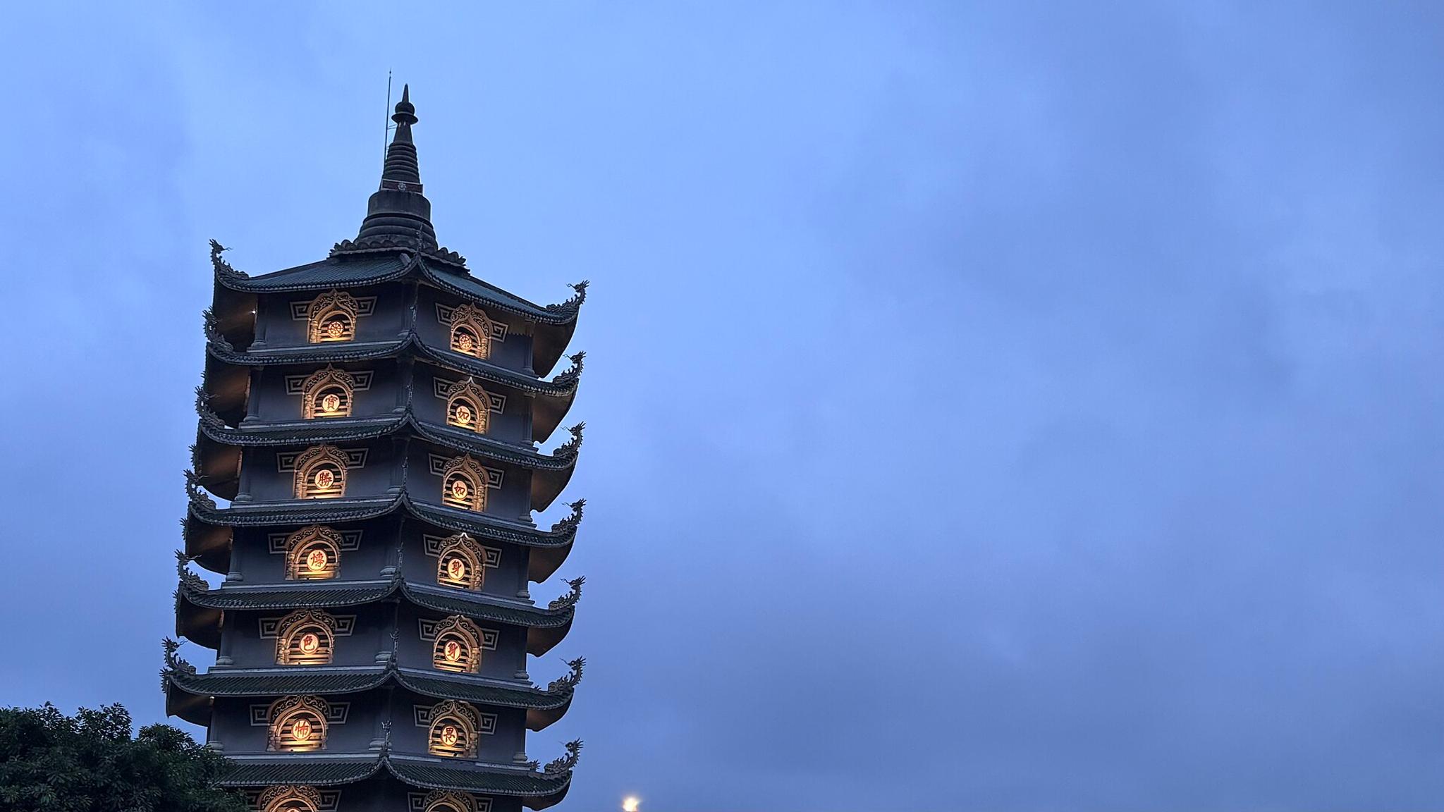 The lit tower of Linh Ung Pagoda on the Son Tra Peninsula at dusk.