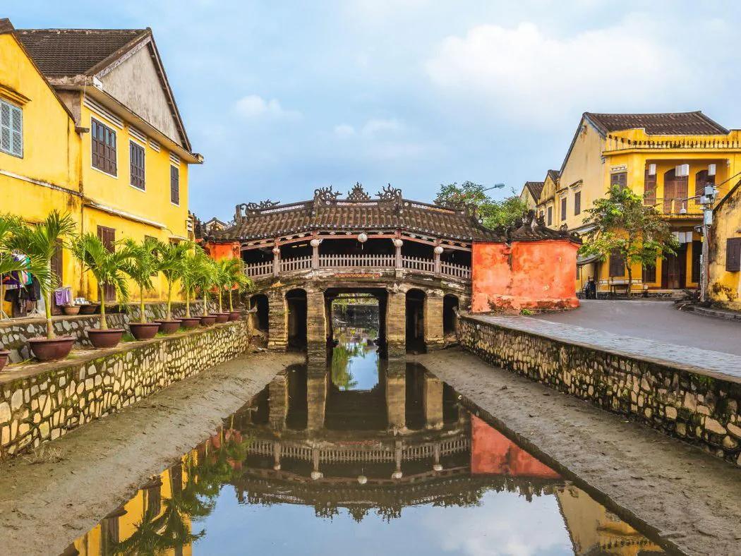 A private group in front of the illuminated Japanese Covered Bridge in Hoi An at night.