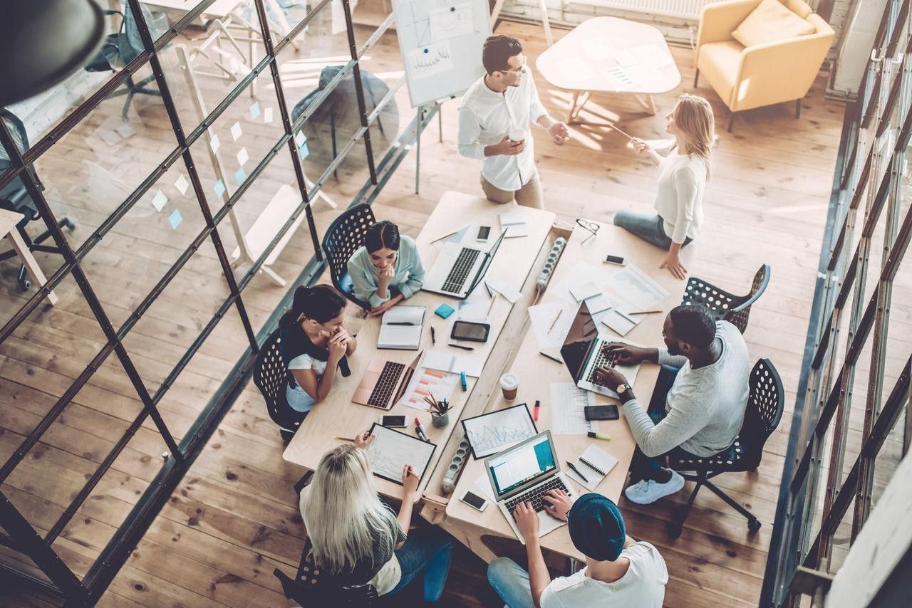 A modern workplace where diverse teams collaborate using digital tools, adapting to changing business environments through innovation, leadership, and organizational agility.