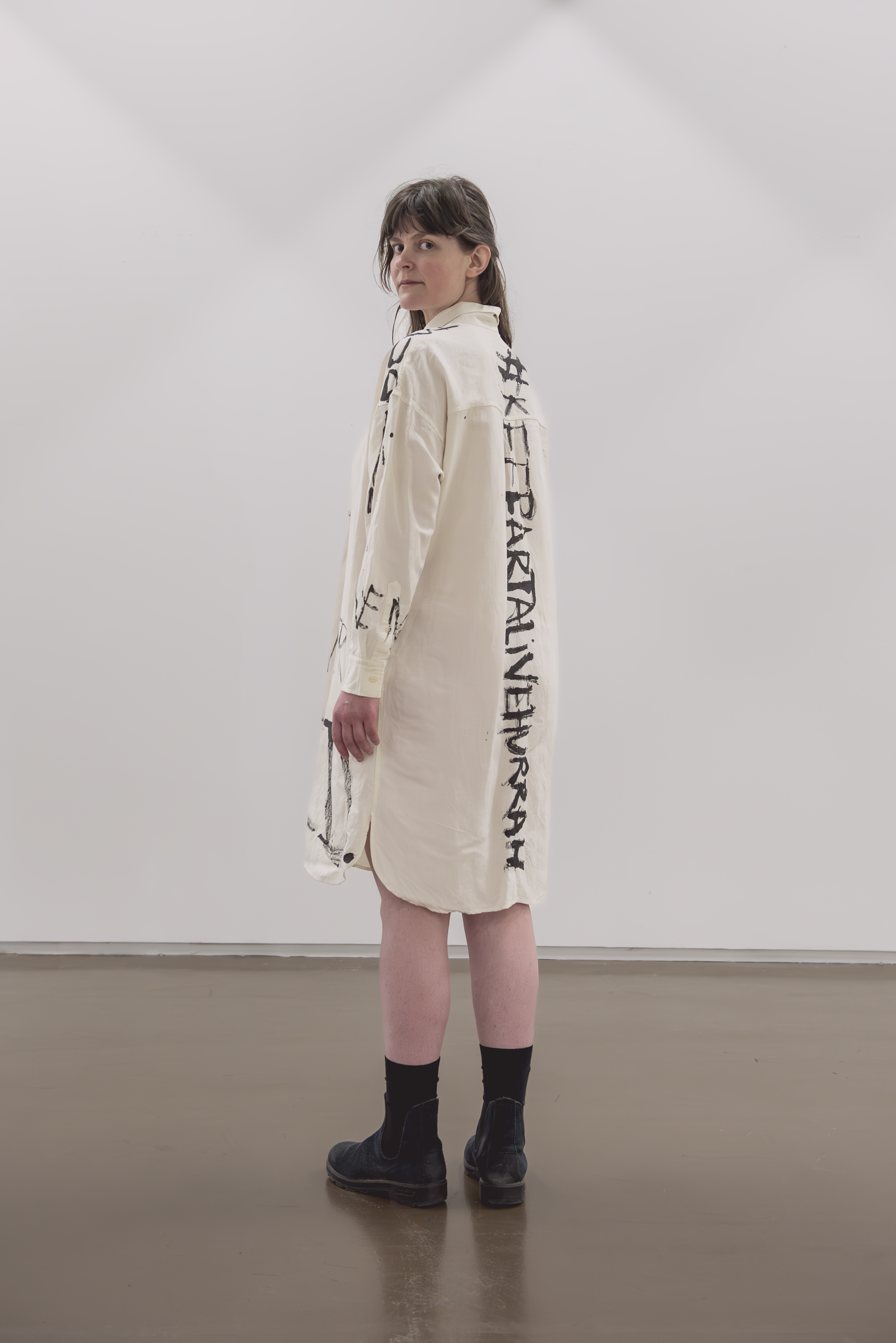 a woman wearing a white dress. she is staring at the camera