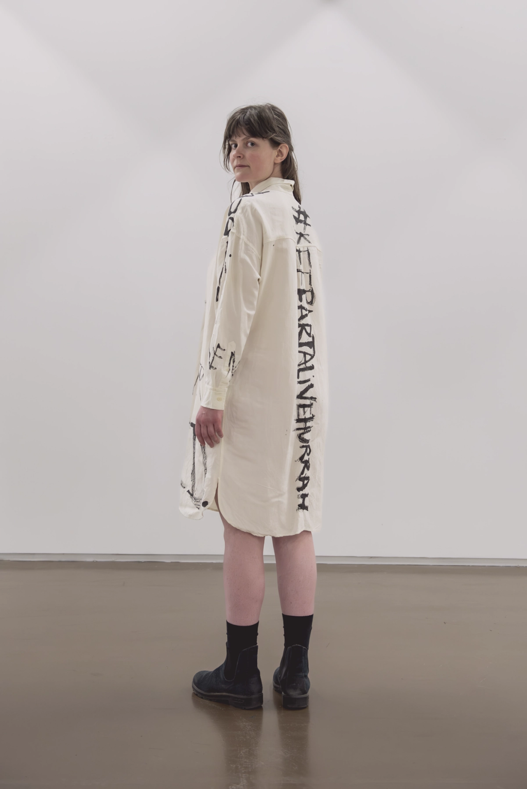 a woman wearing a white dress. she is staring at the camera