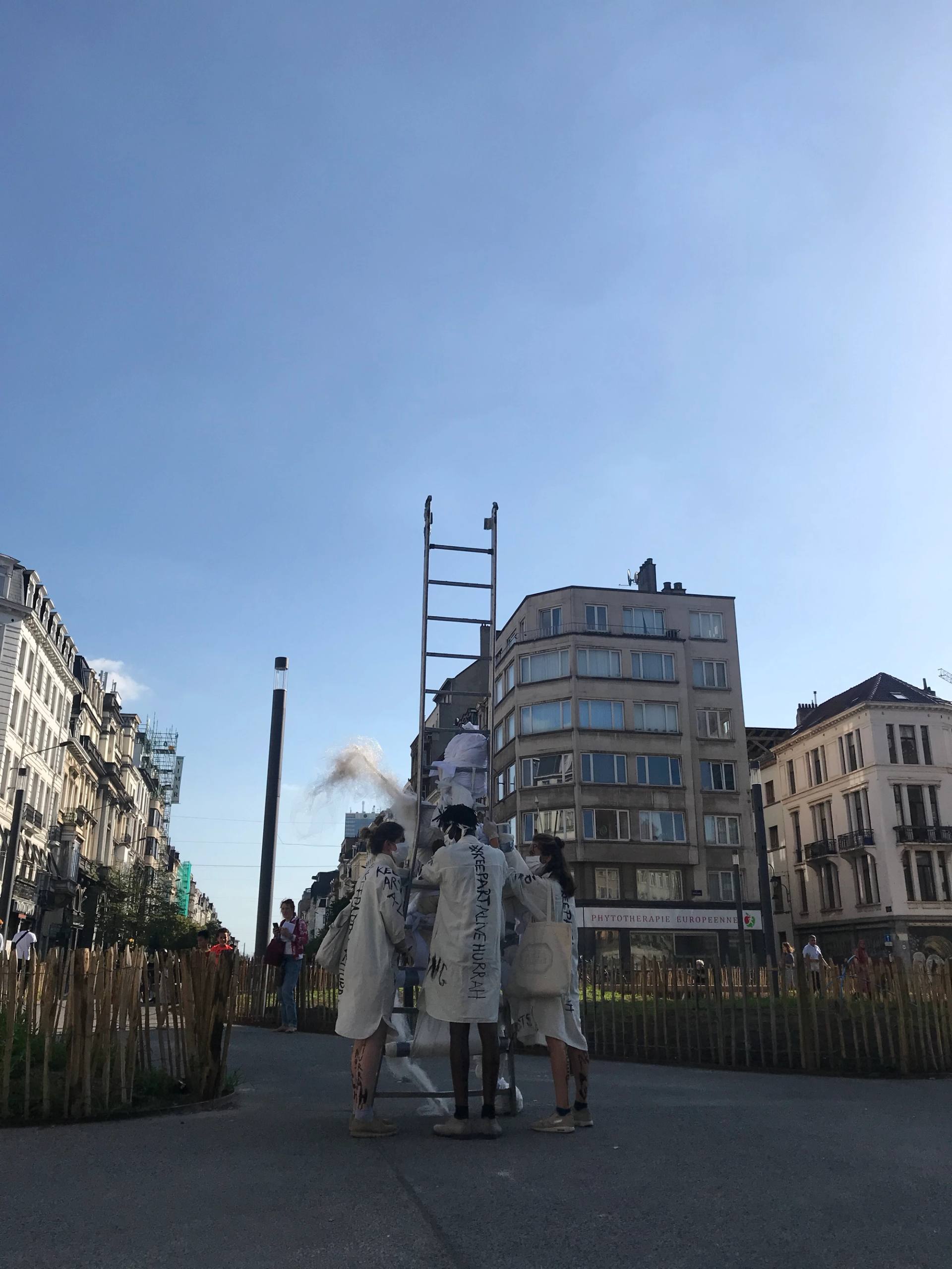 performers standing in the street with a giant ladder