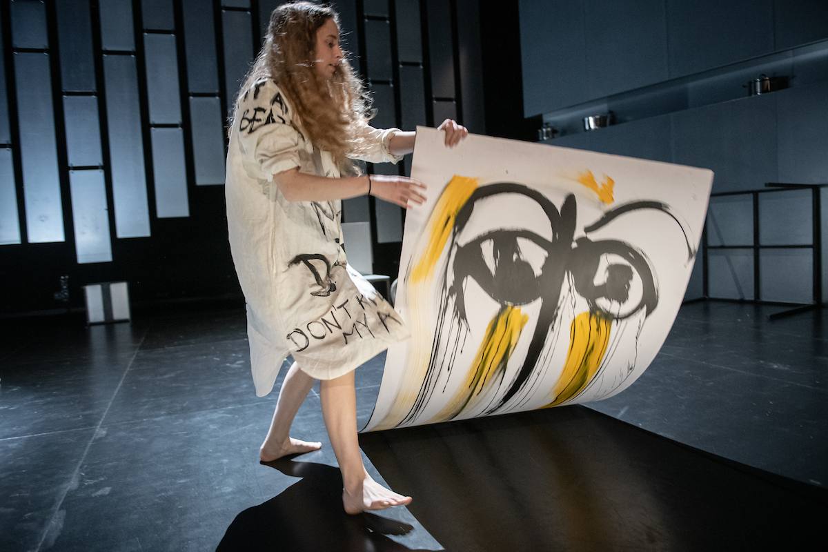 a girl lifting up a painting