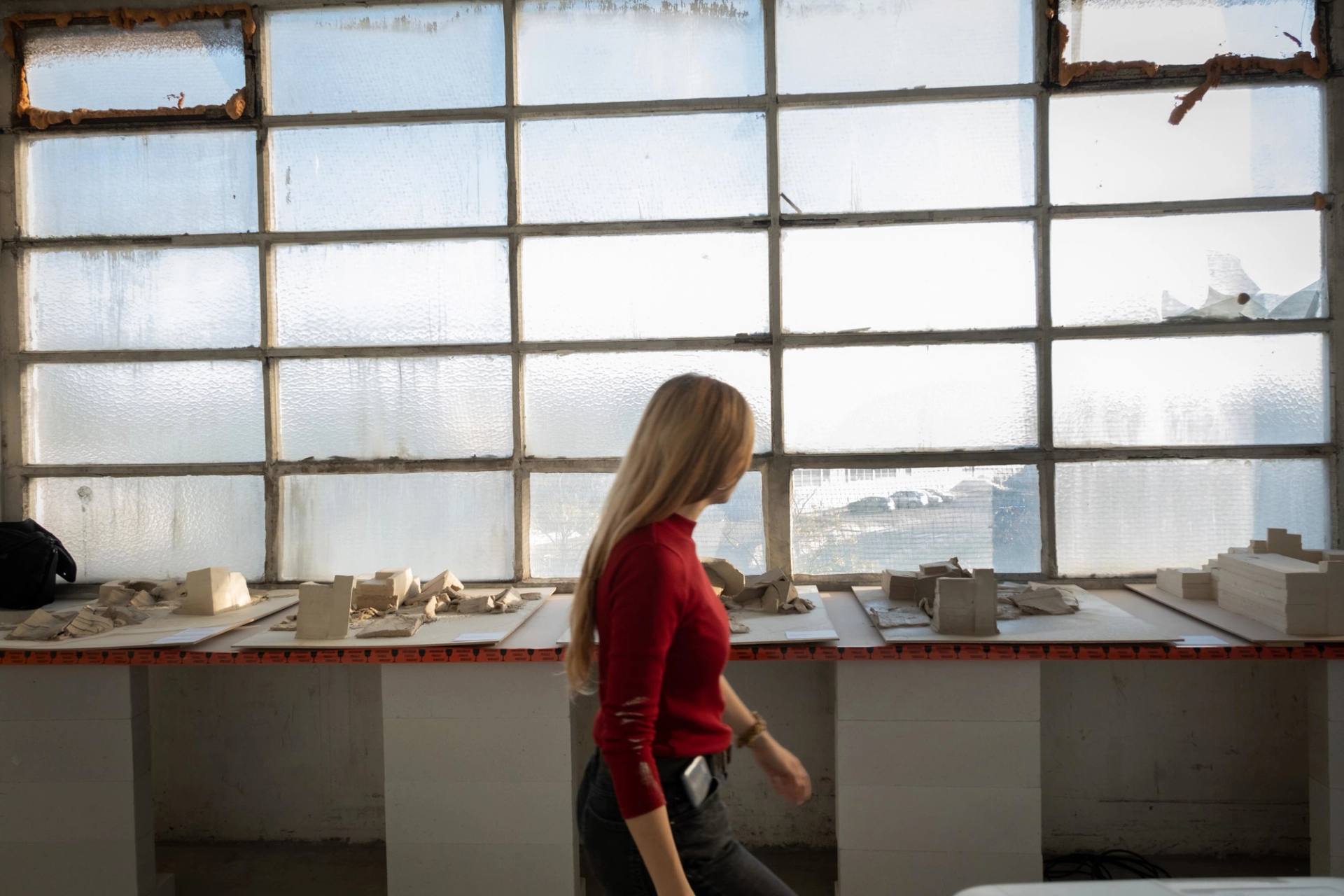 a girl passing in front of destroyed buildings