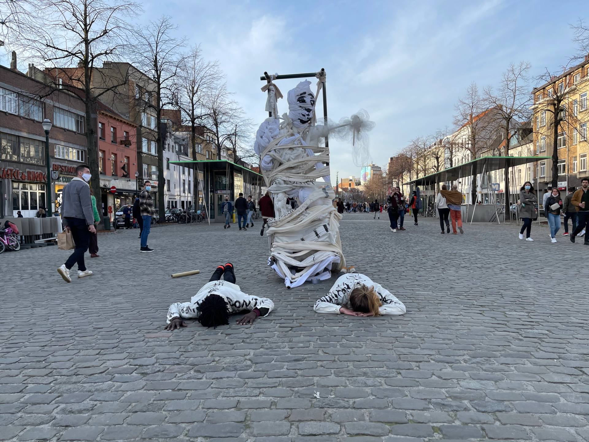 performers on the ground next to a sculpture
