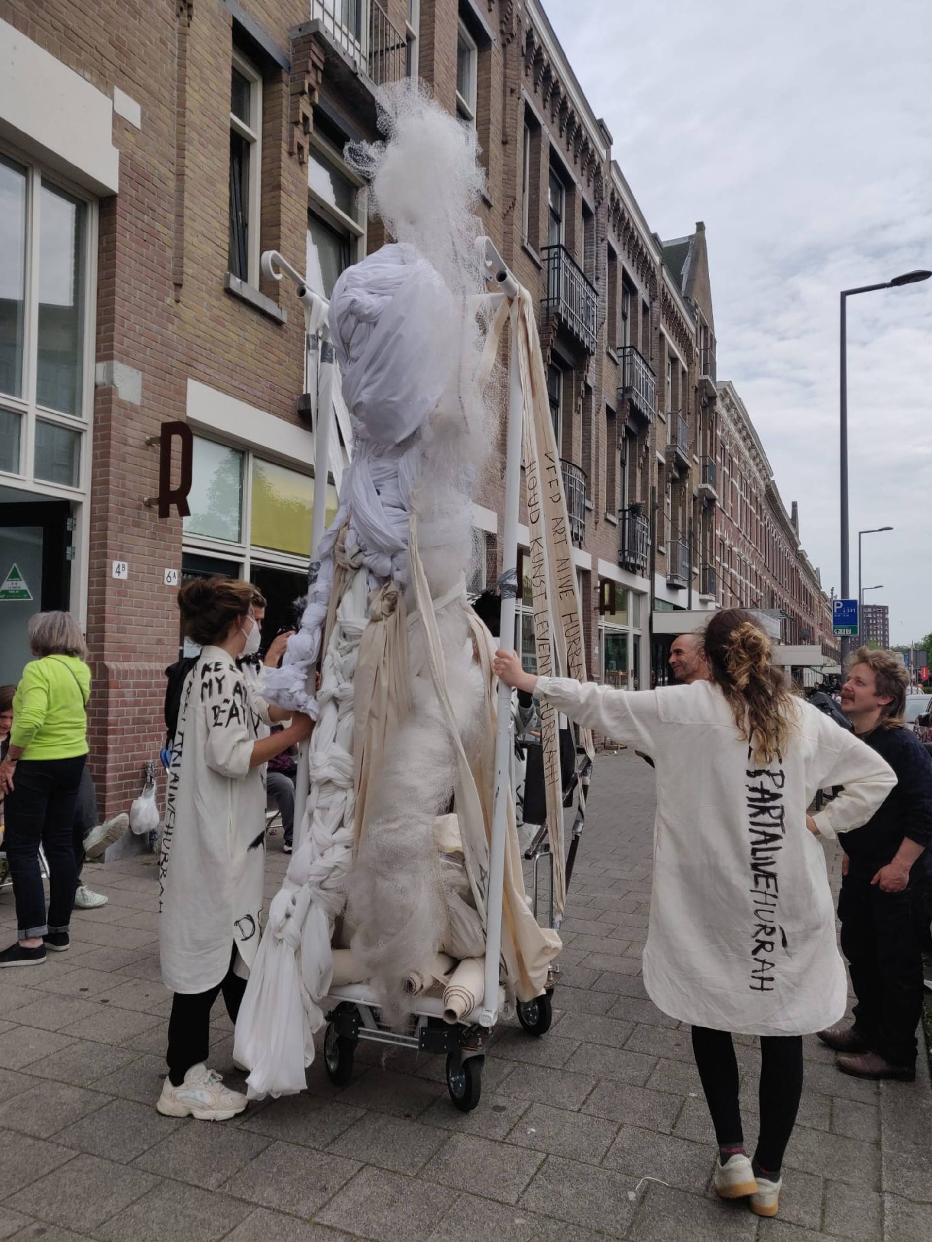 performers standing in the street talking to passers by
