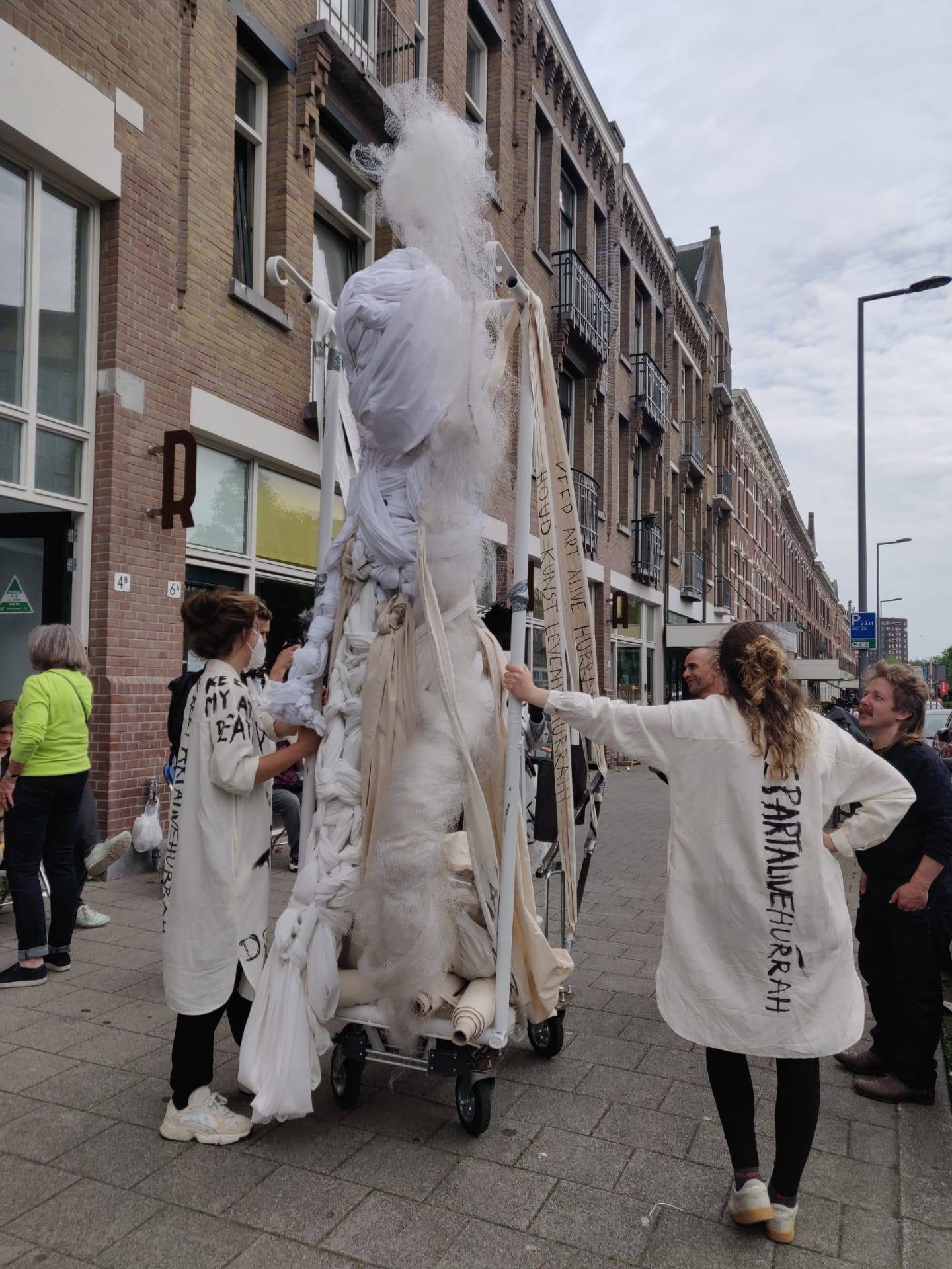 performers standing in the street talking to passers by