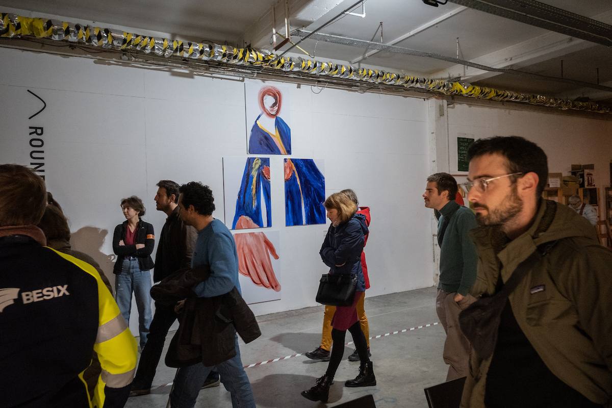 people walking in front of a painting