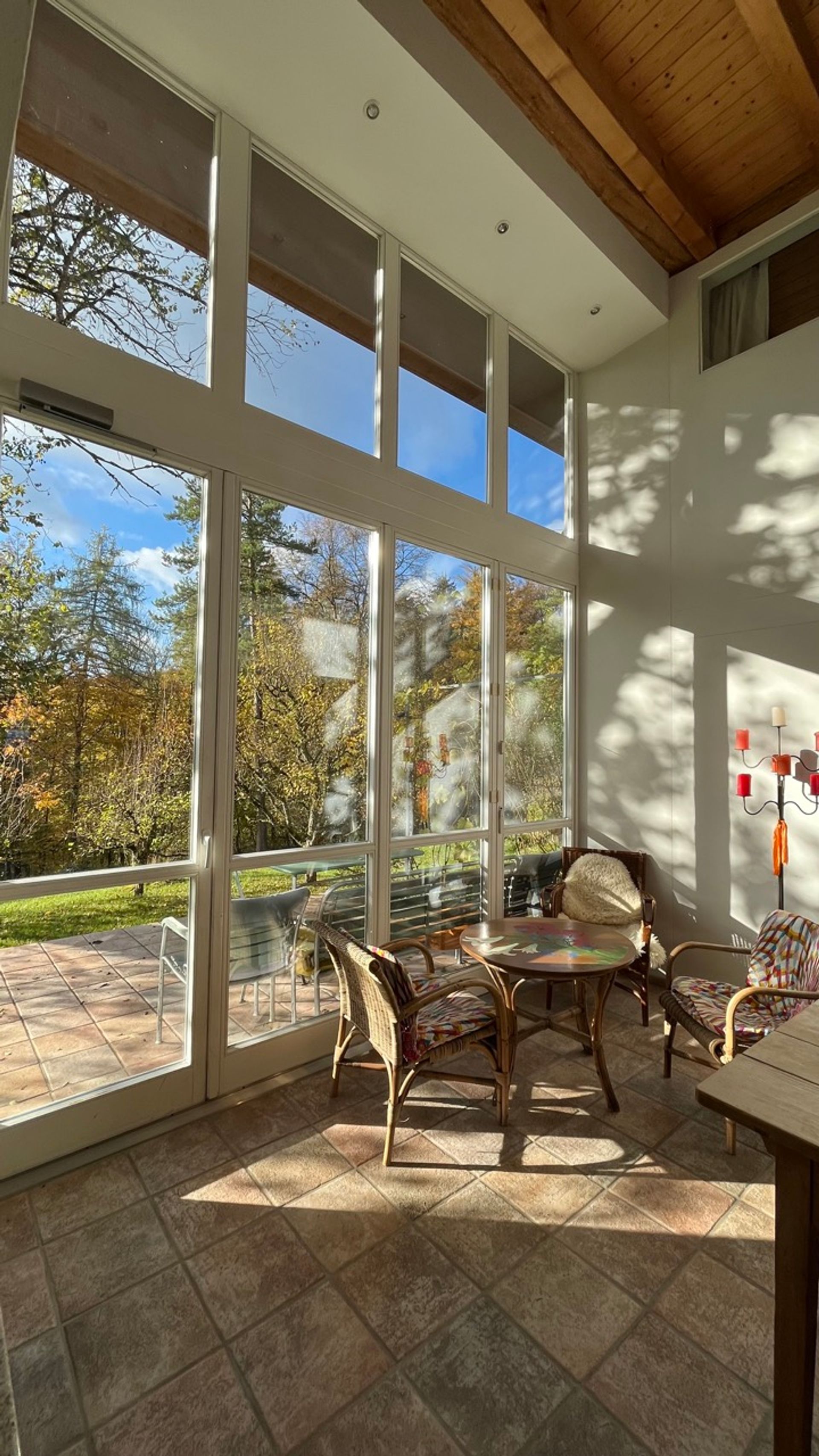 Wohnzimmer der Herberge mit Fensterfront zum Garten
