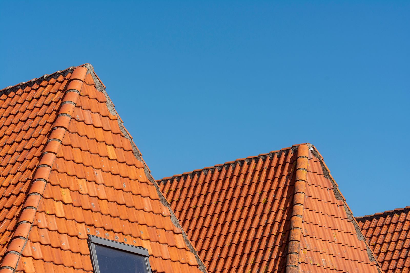 Oranje pannendak tegen een blauwe lucht