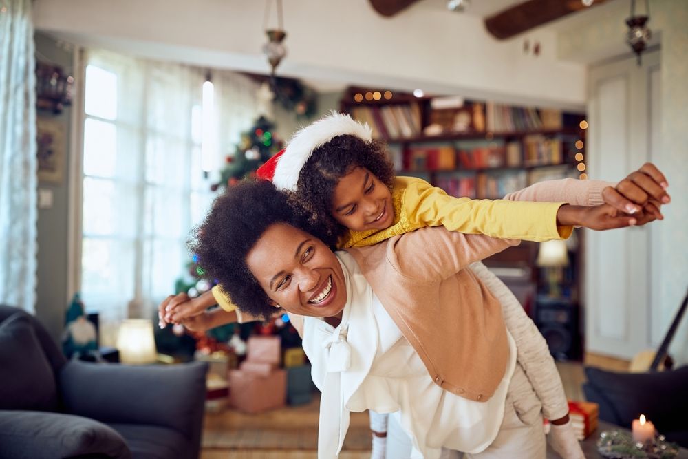 Holiday co-parenting tips for first-time co-parents as a parent and child celebrate the holiday season together at home.