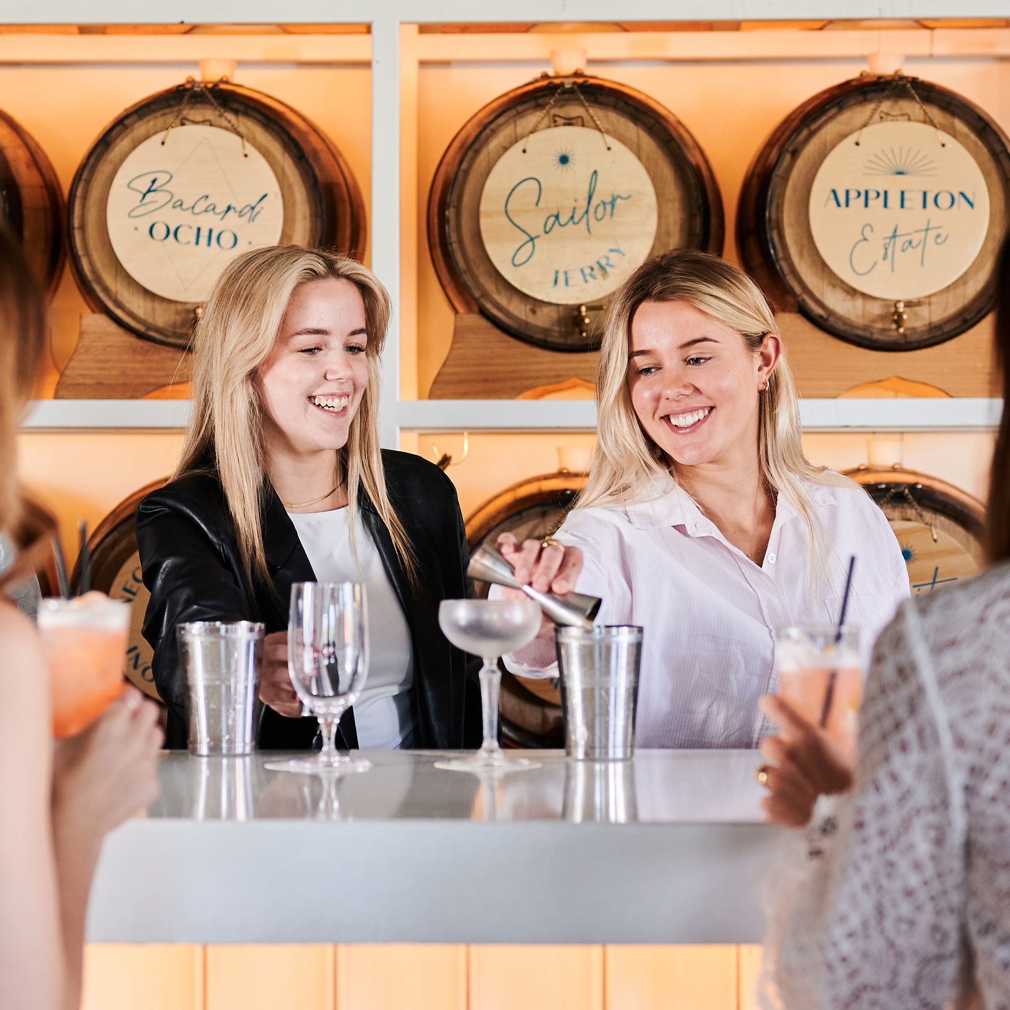 Girl's shaking a cocktail behind the bar