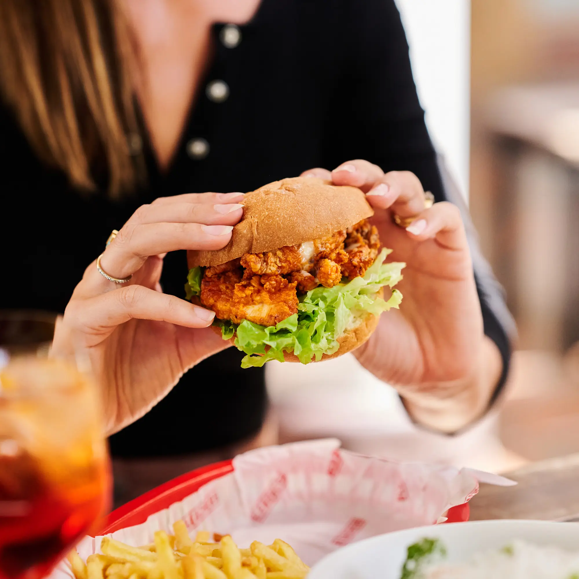 Woman holding Bleachers burger