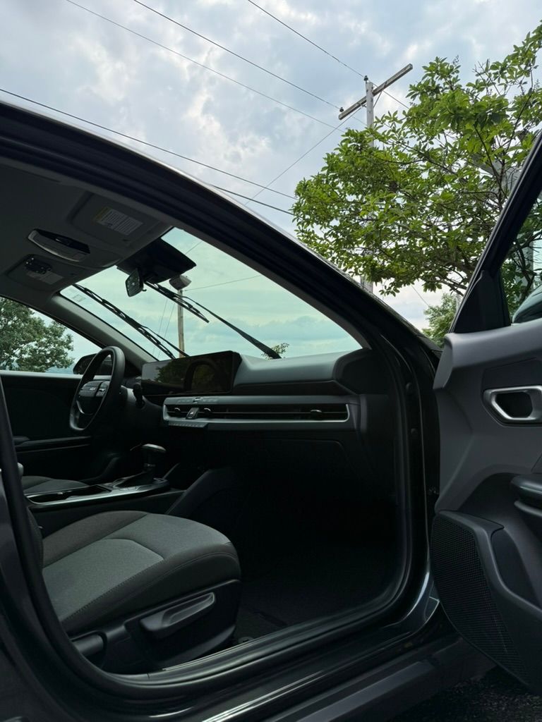The interior of a Kia K4. The car has gray seats and a black dashboard. The car is recently detailed.