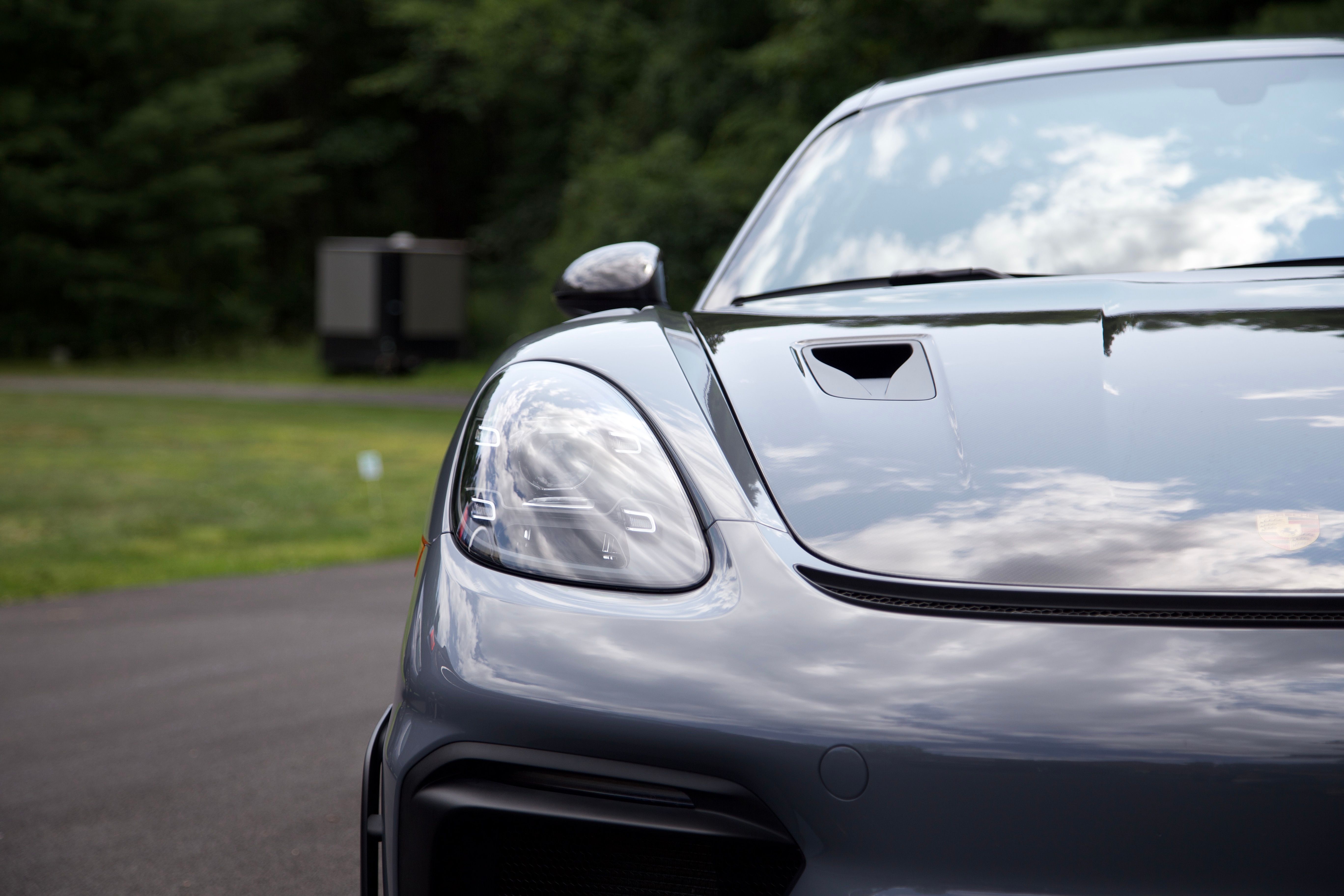 A photo taken head-on displaying the passenger half of a Porsche GT4RS. The headlight is clearly in view, and the paint is pristine.