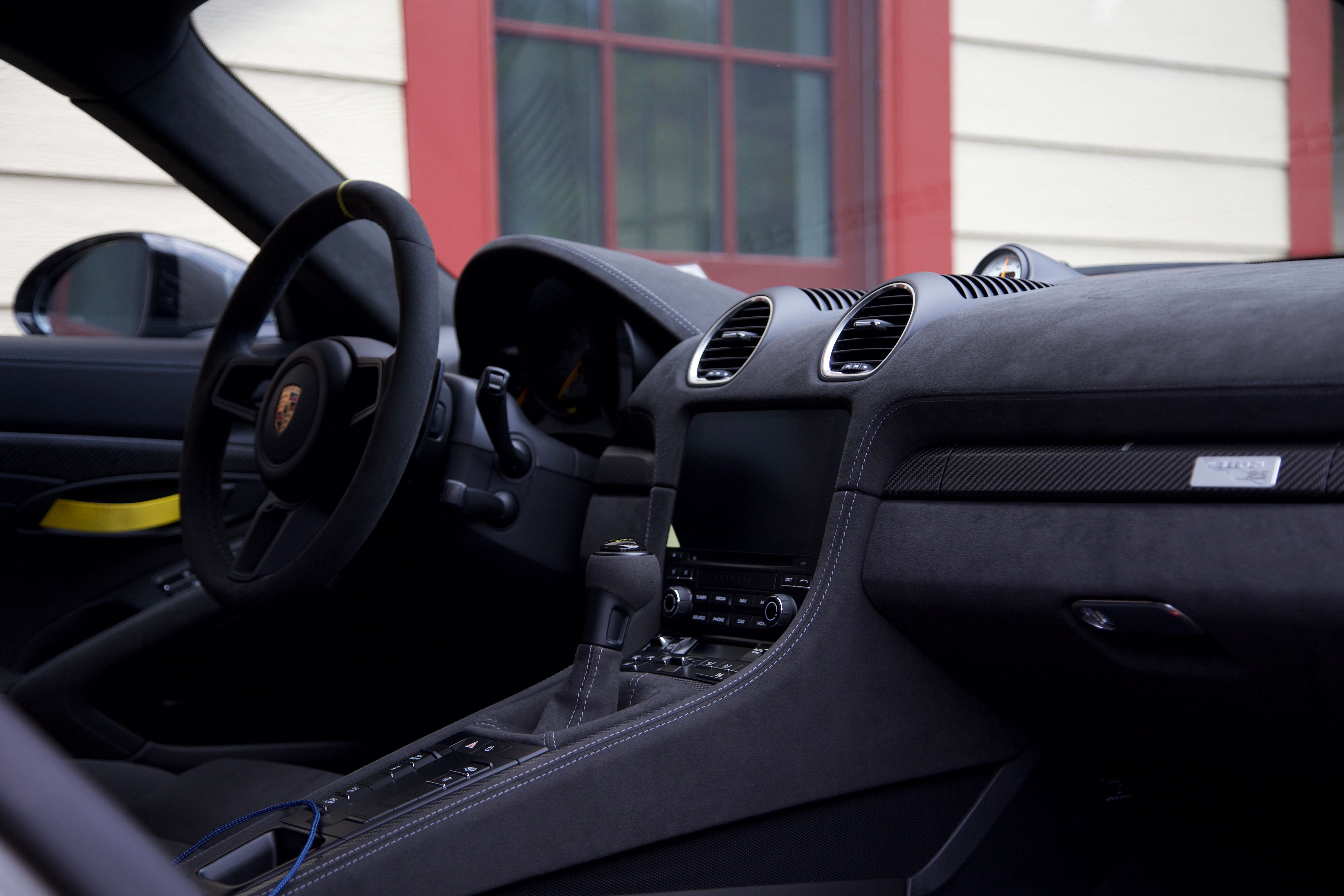 The interior of a freshly detailed Porsche GT4RS, taken from the passenger side. You can see the steering wheel, center console, glovebox, and dashboard.