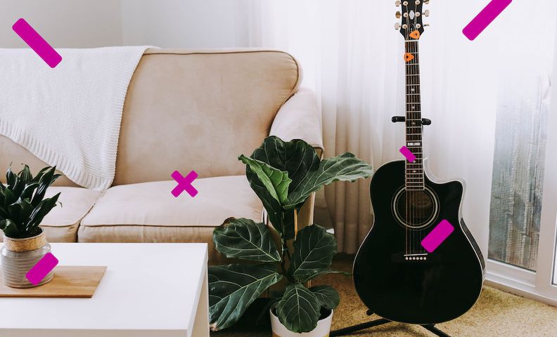 Kuva sohvalla, sohvapöydällä ja kitaralla sisustetusta huoneesta