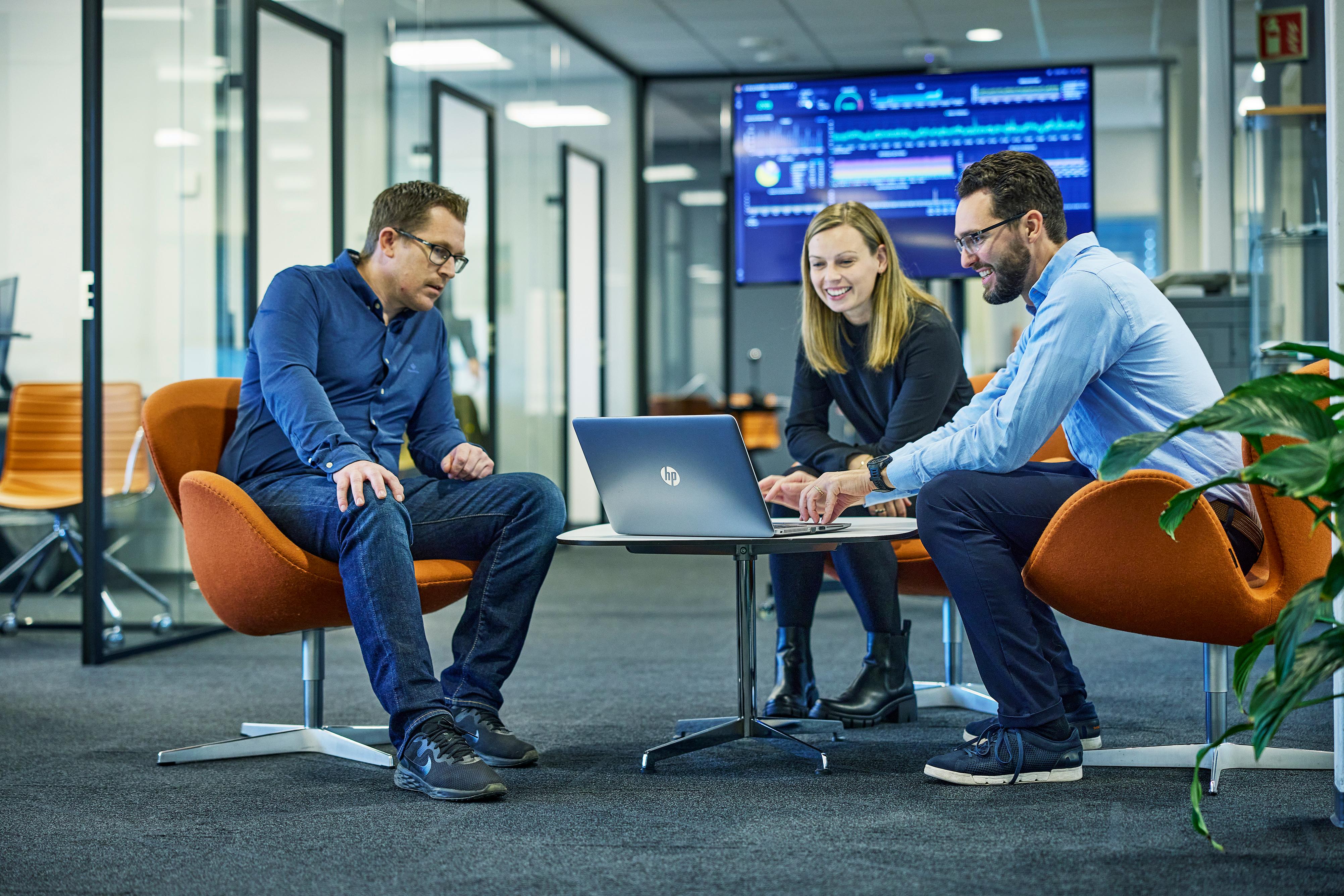 Three people gathered around a laptop with Envo's solution