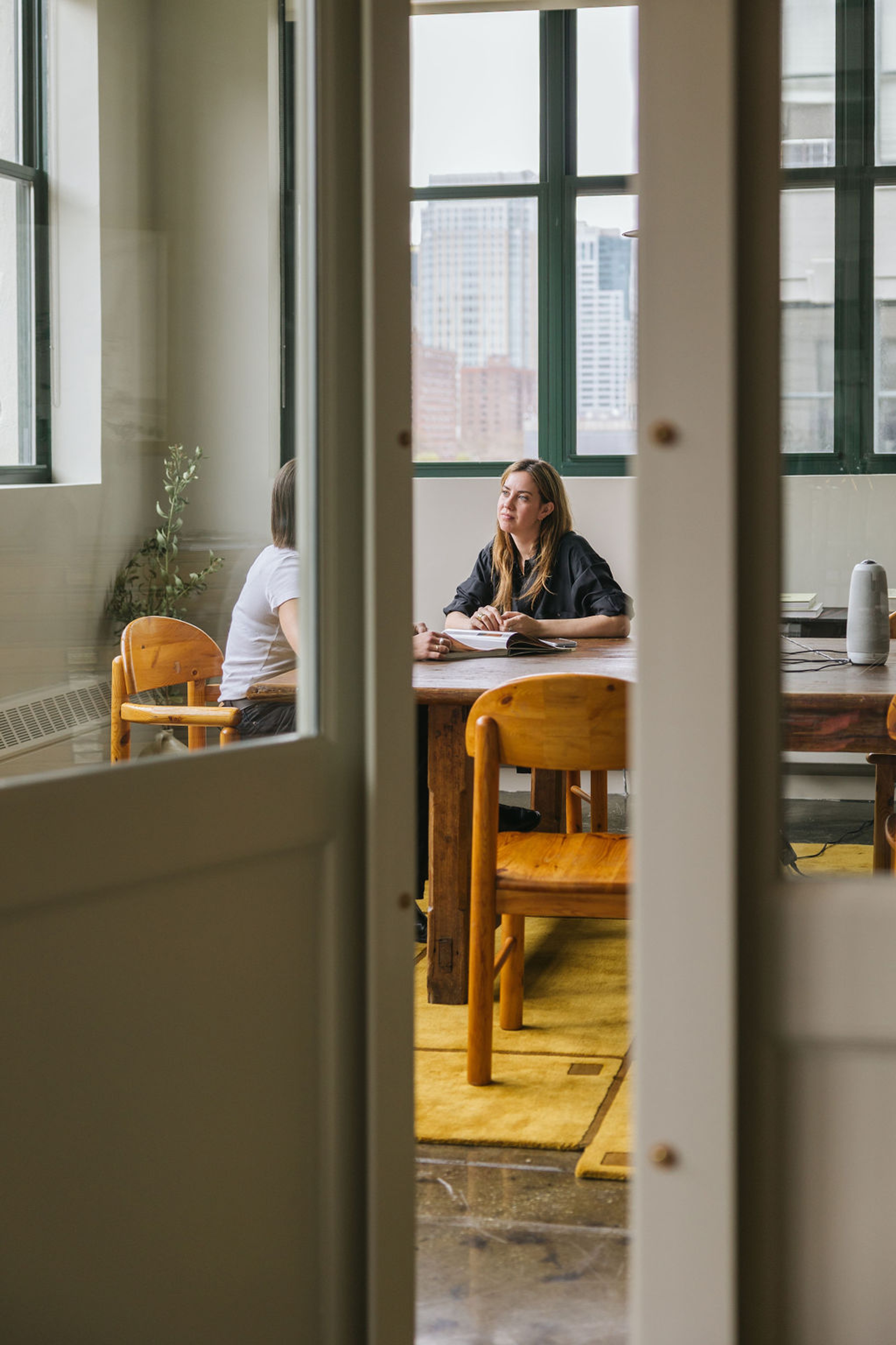 Two women working in a corner conference room