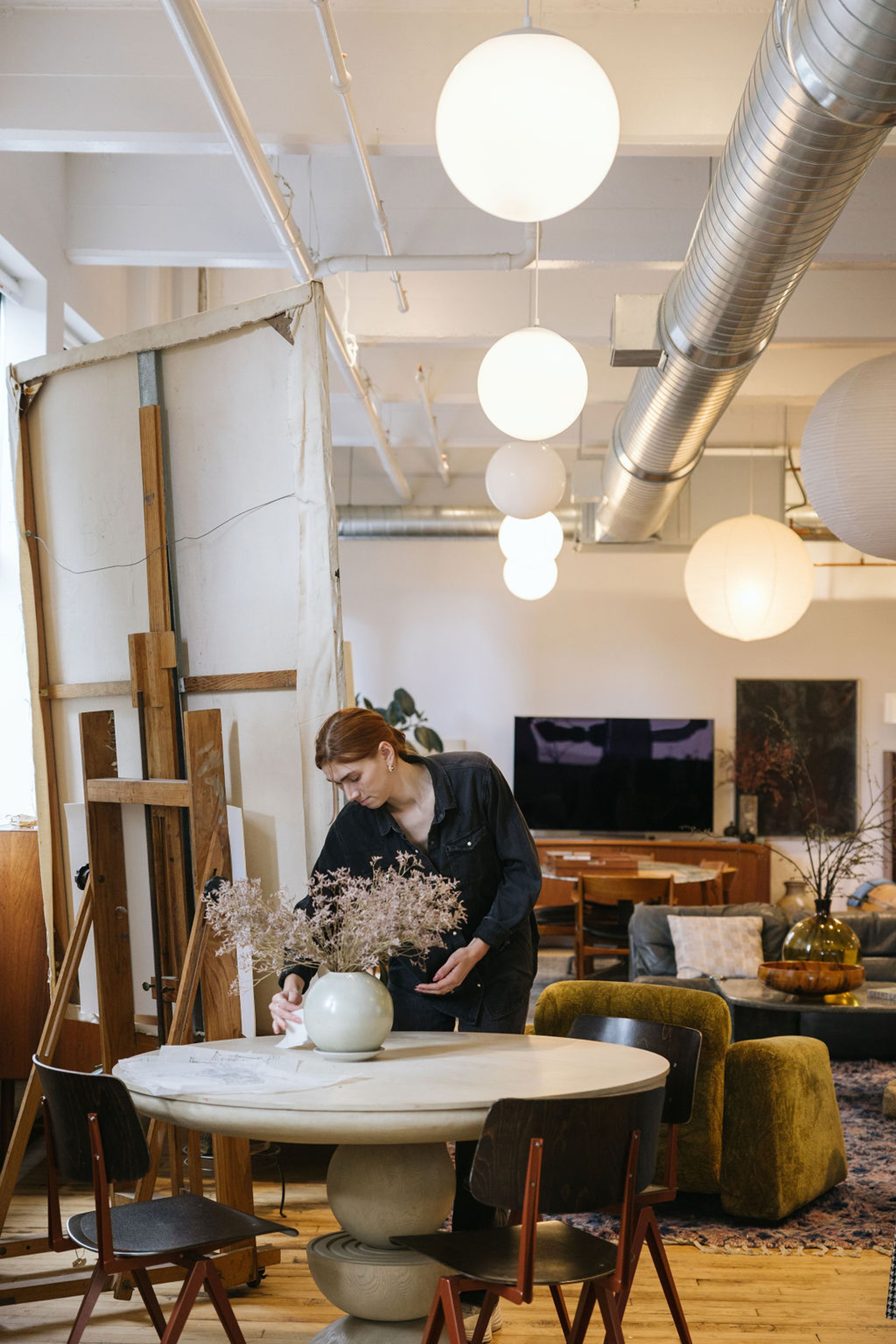 Woman standing over table with floral arrangement