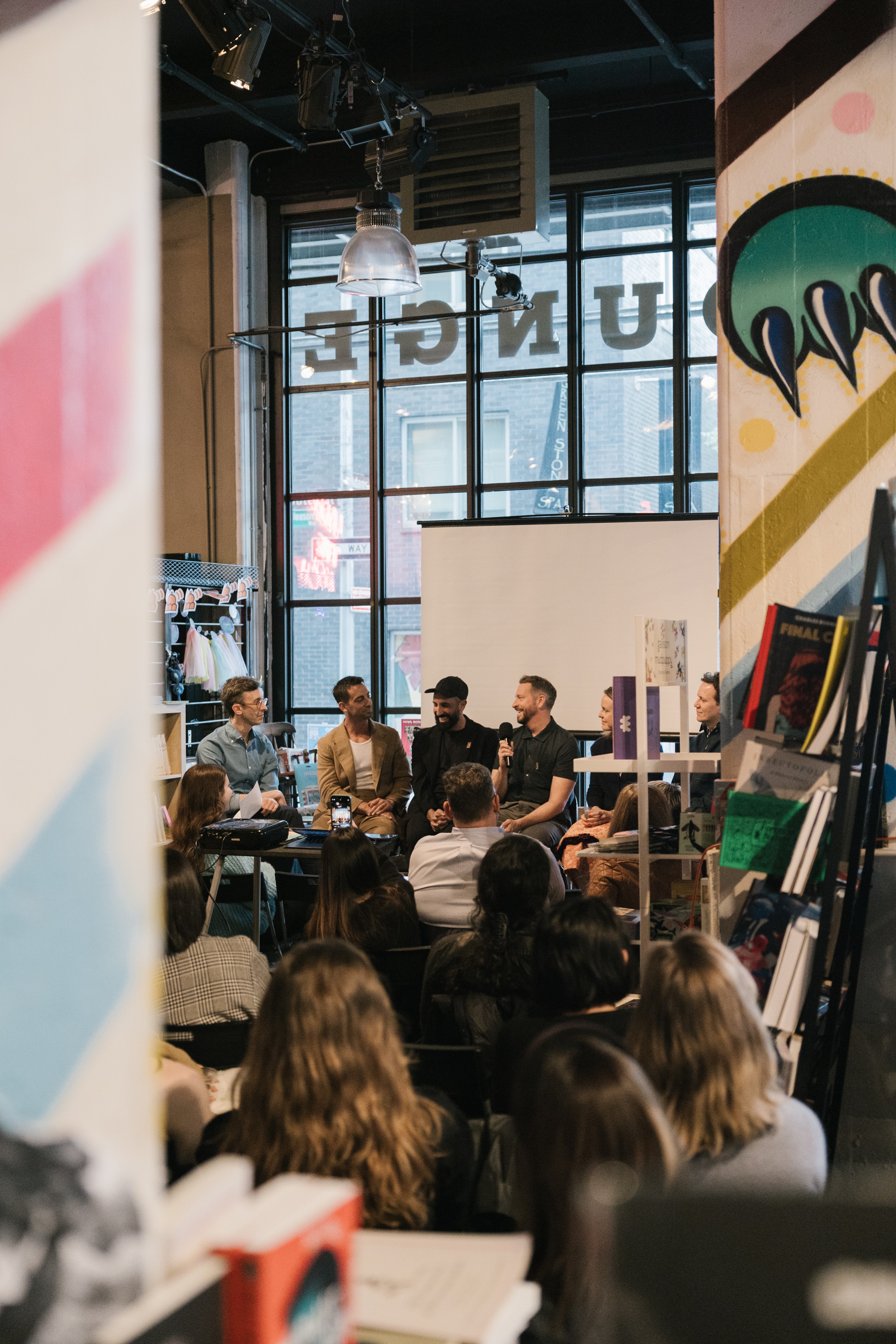 Six people seated at a book talk at Powerhouse Arena