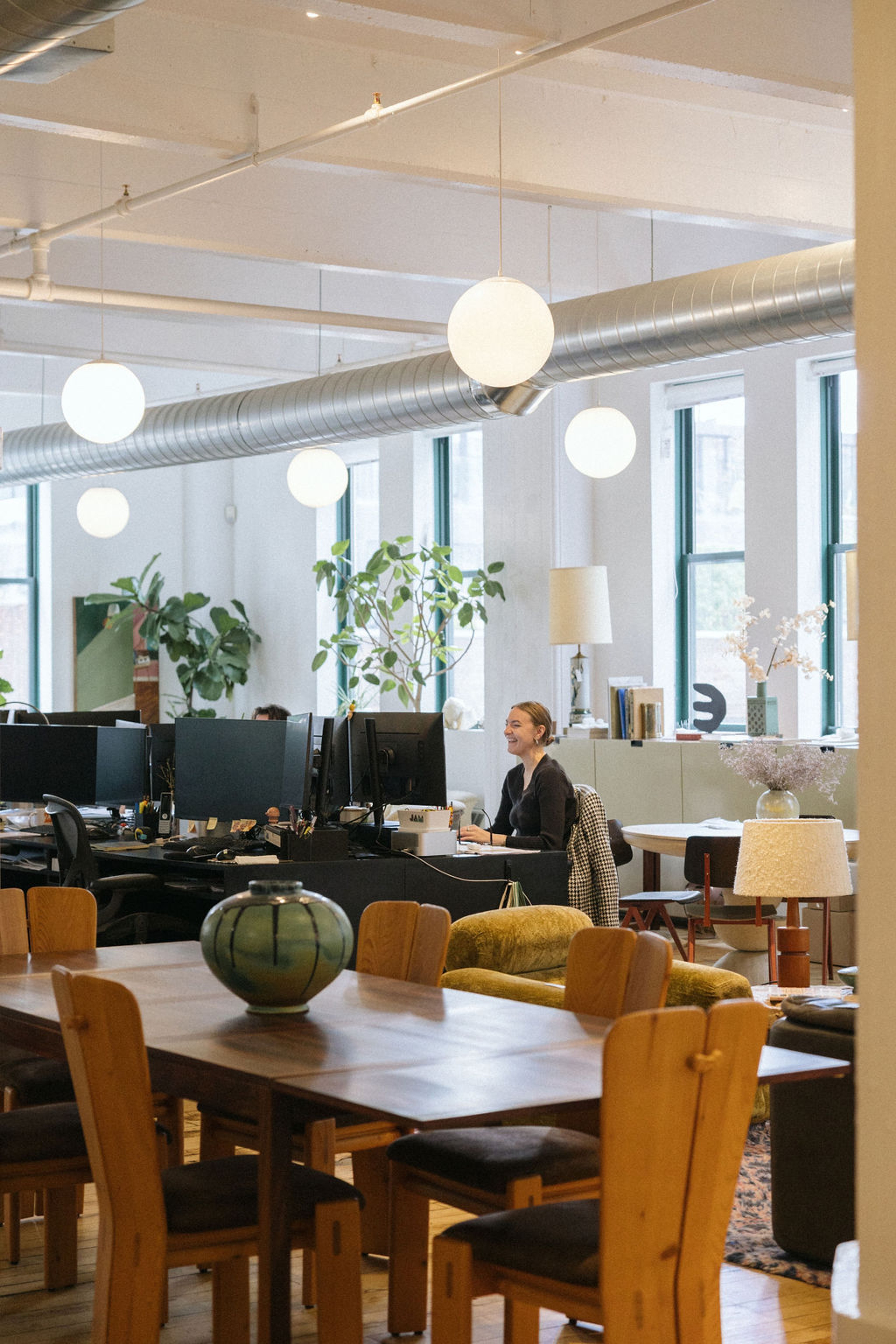 Custom designed wood table with woman at computer in the background