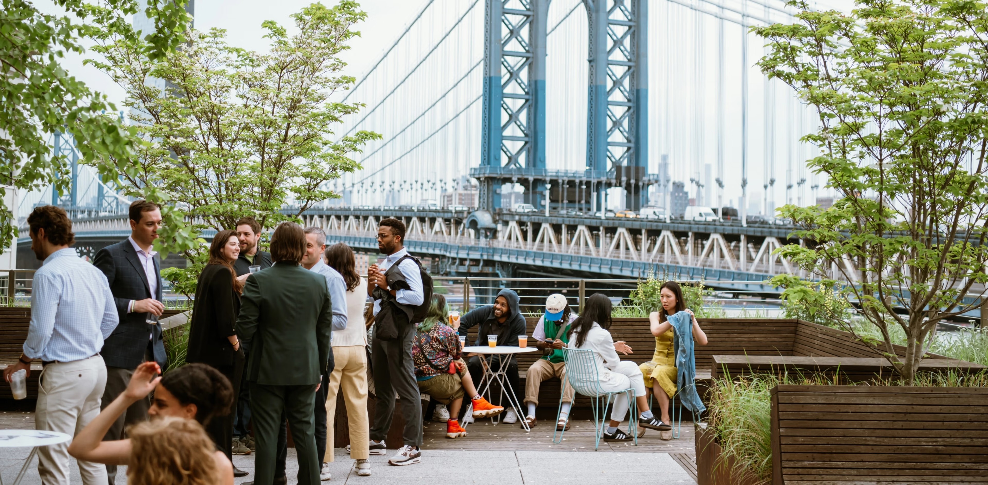 employees socializing on brooklyn rooptop overlooking Manhattan Bridge