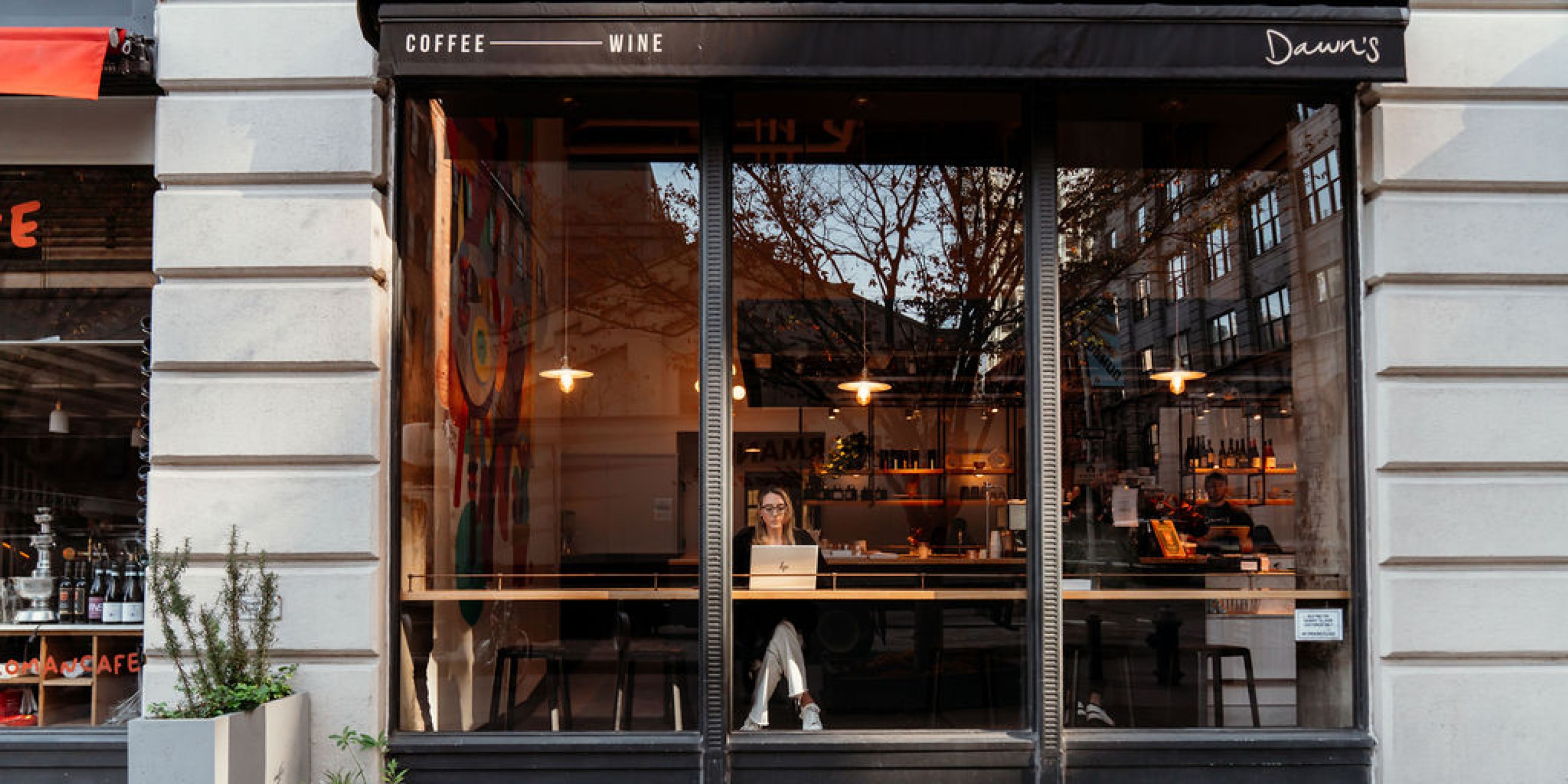 Women working on laptop in window of coffee shop
