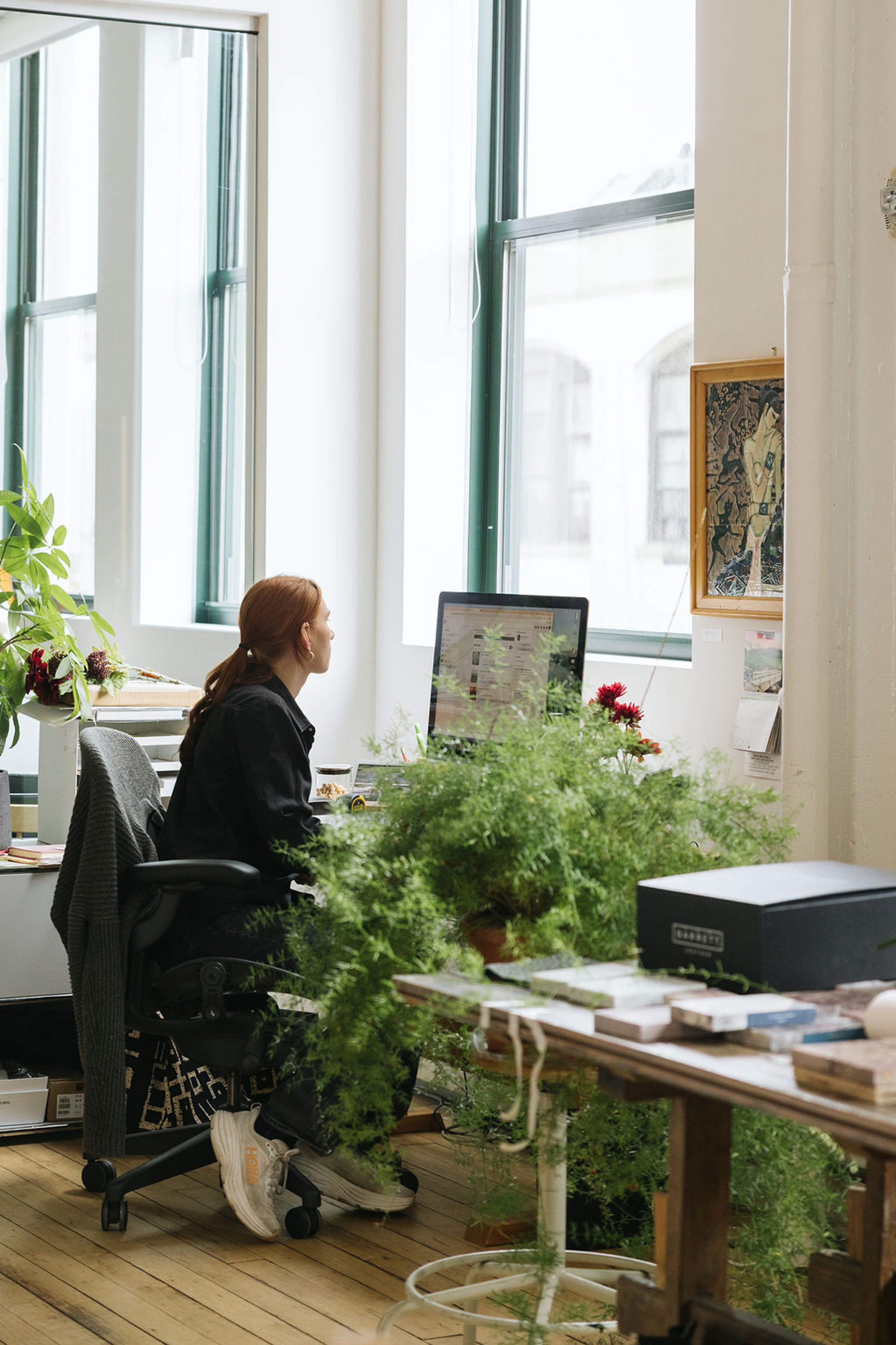 Woman at computer near large window