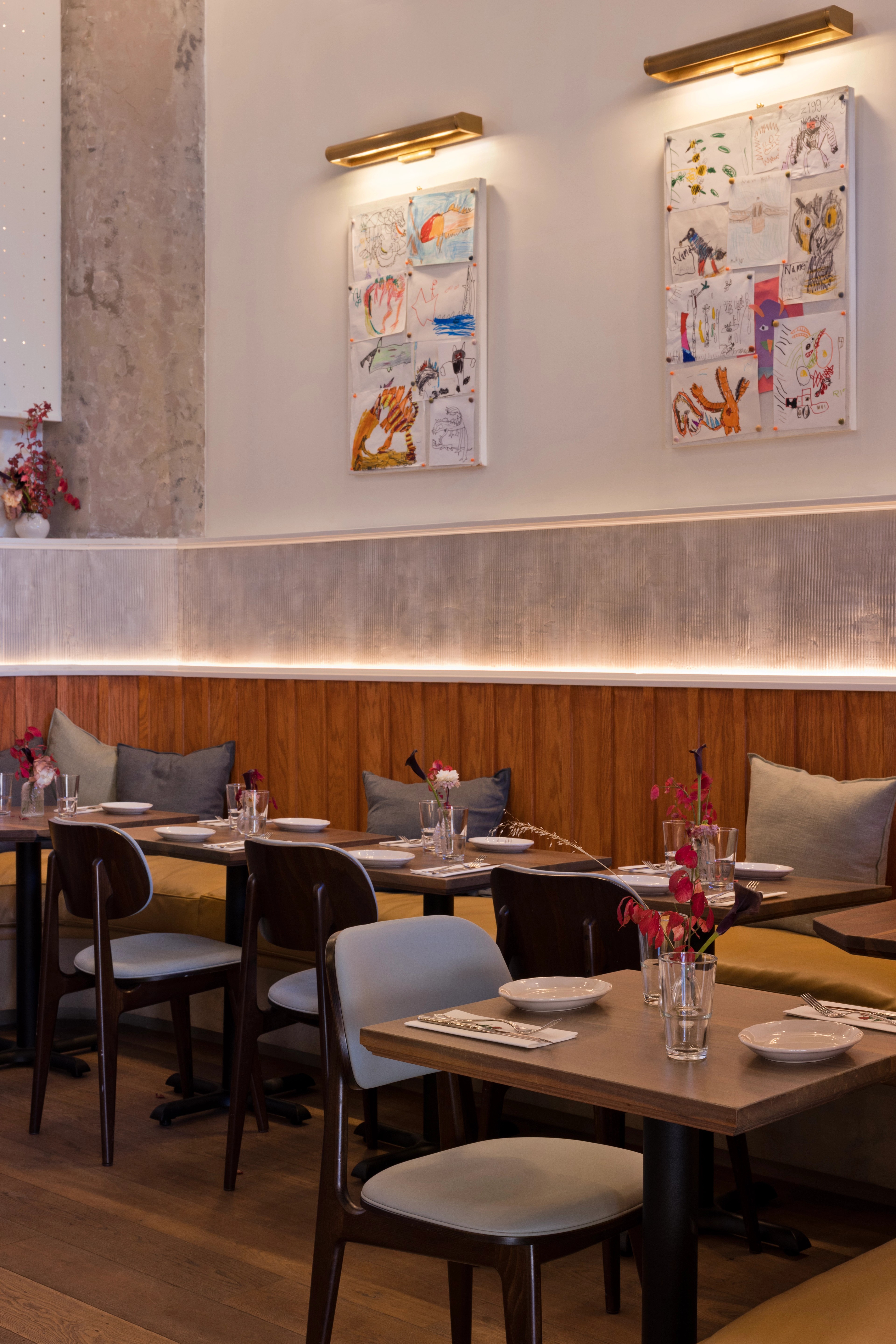 Restaurant tables with place settings and art on the wall