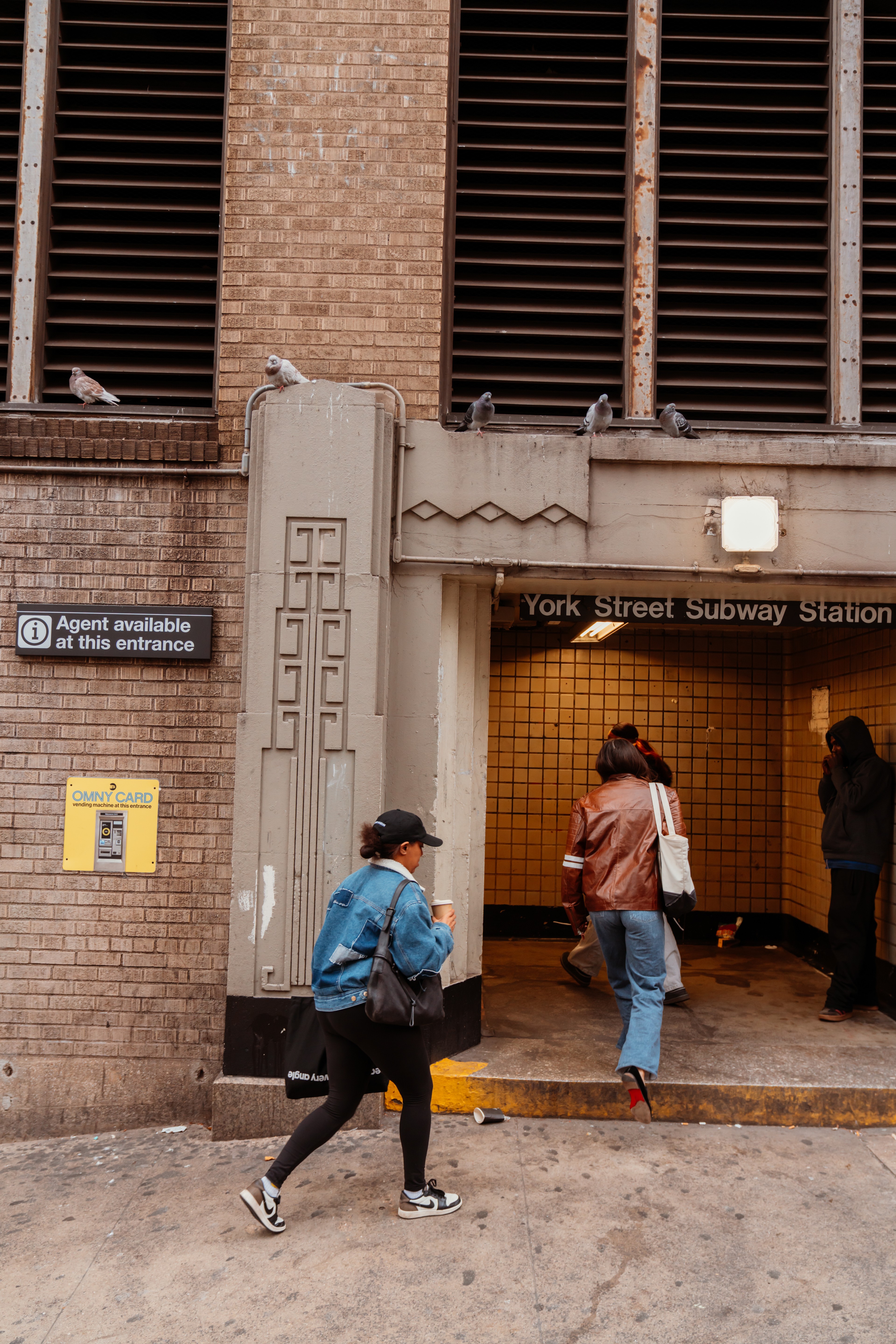 Woman walking into F train entrance