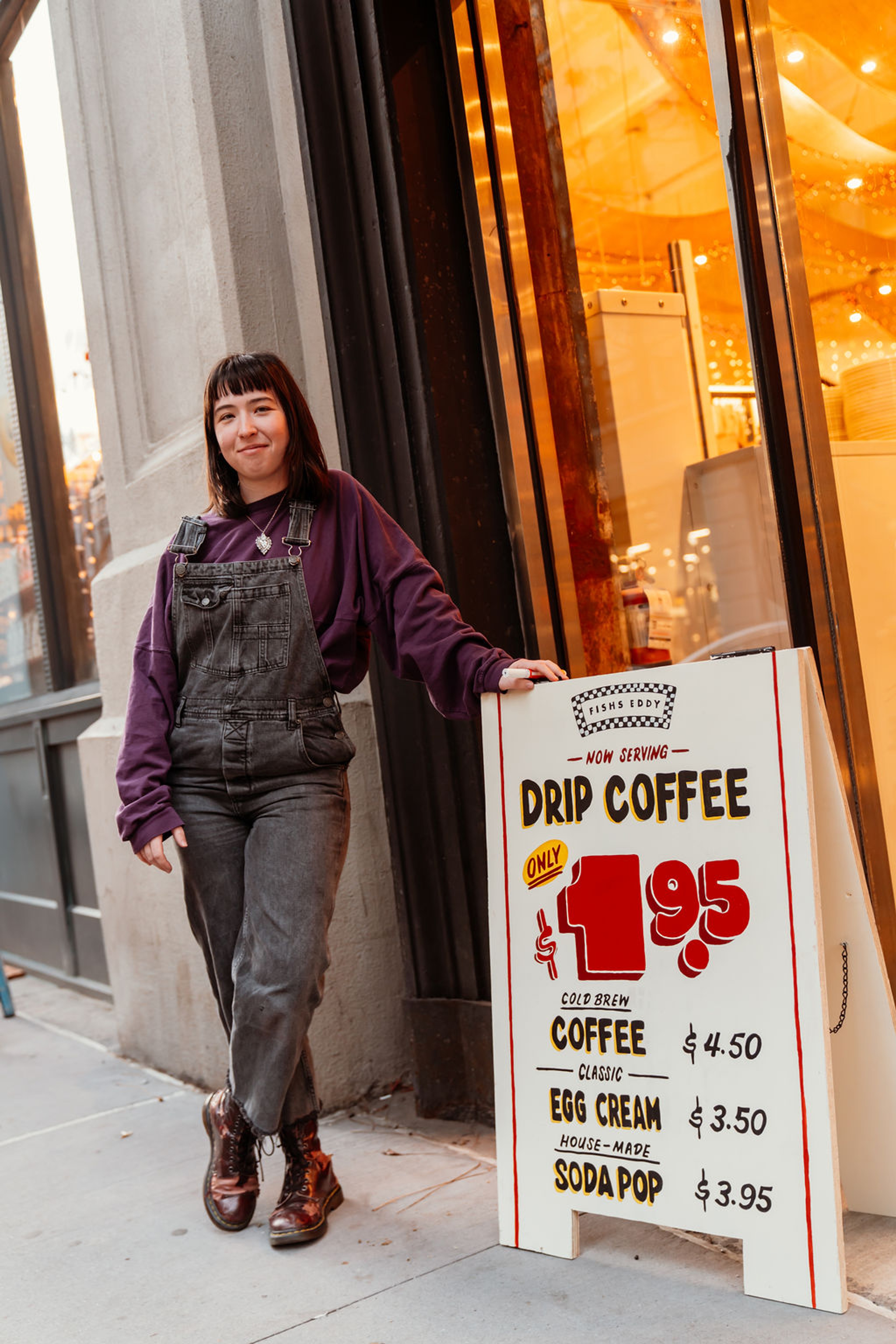 Fishs Eddy Employee standing next to sidewalk sign